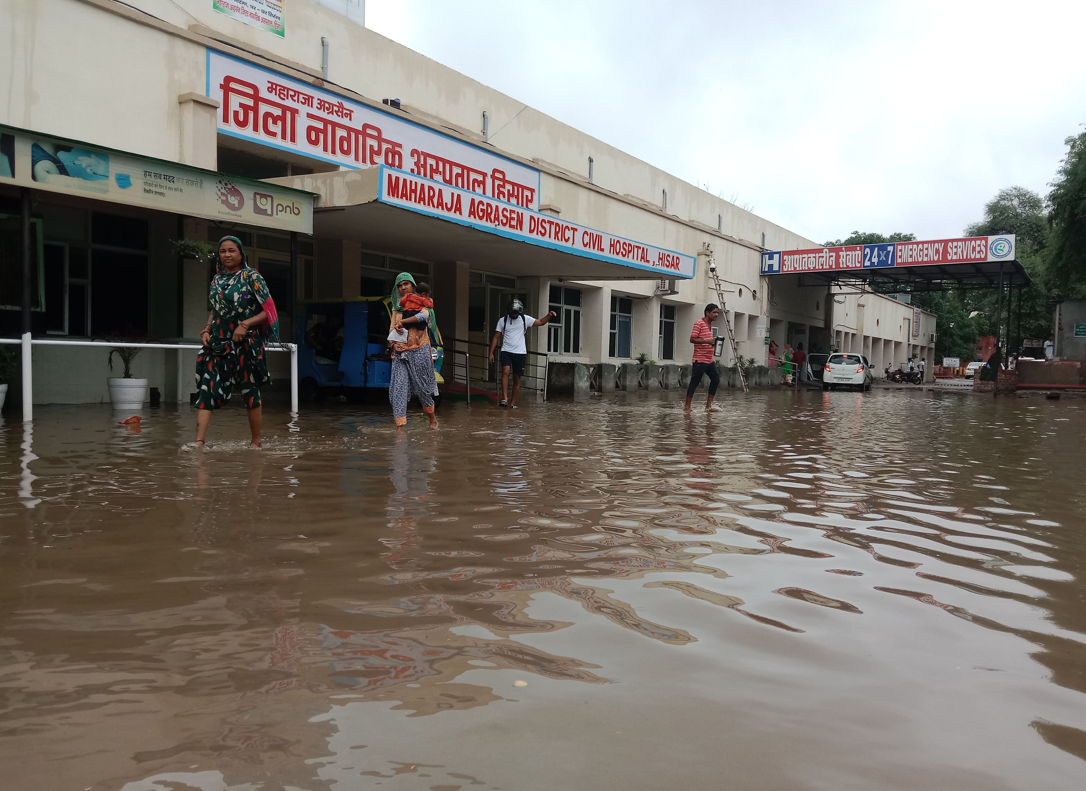हिसार जिला नागरिक अस्पताल में बरसात के बाद भरे पानी से गुजरते लोग संवाद हिसार जिला नागरिक अस्पताल में बरसात के बाद भरे पानी से गुजरते लोग संवाद