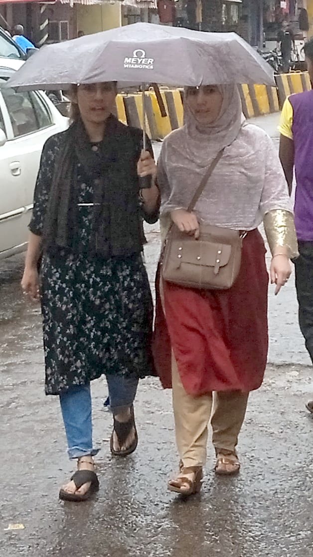 शामली में बारिश में छाता लगाकर गुजरती युवतियां। शामली में बारिश में छाता लगाकर गुजरती युवतियां।