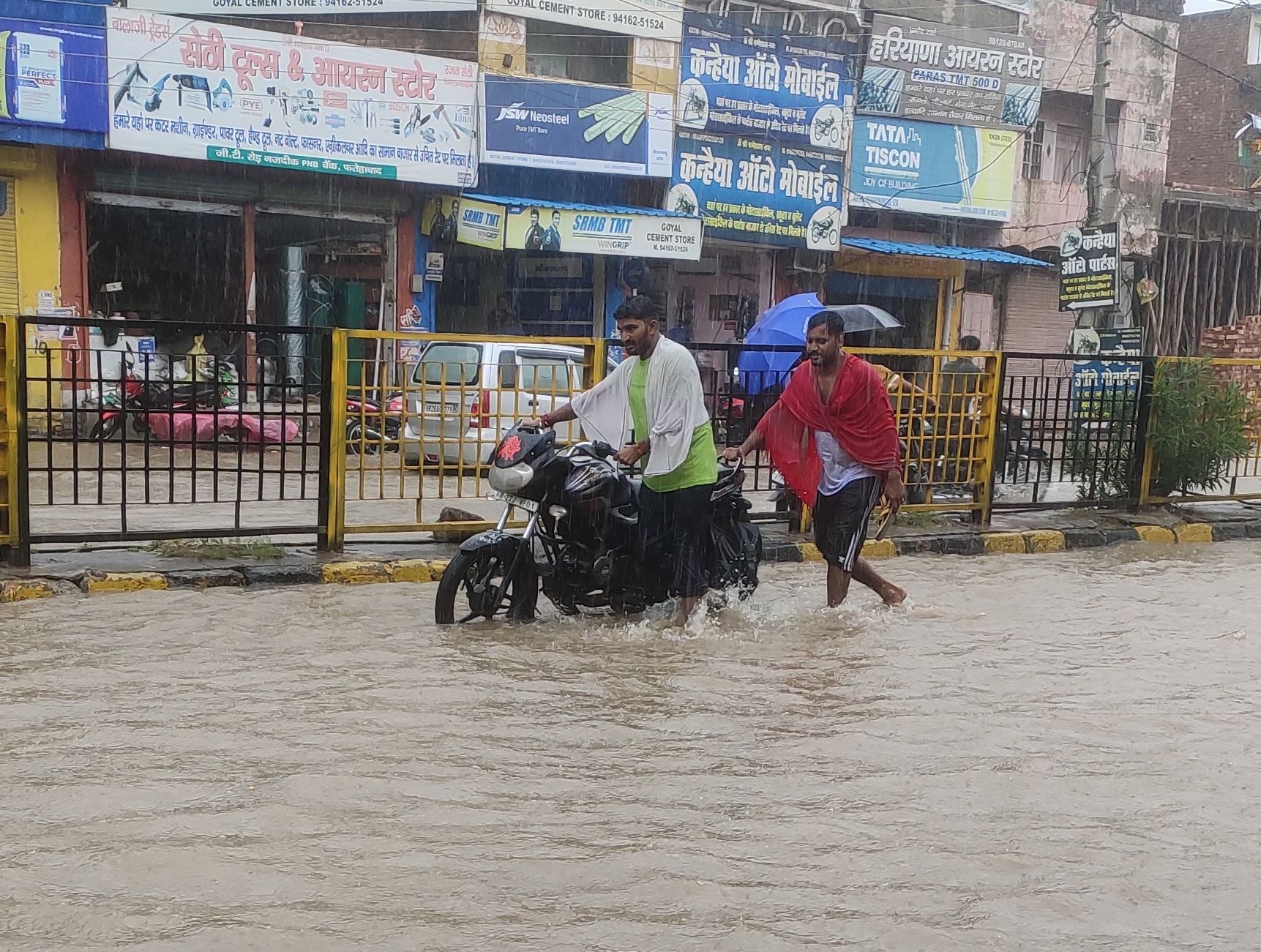 जलभराव में बाइक बंद होने पर घसीटकर ले जाते बाइक चालक। जलभराव में बाइक बंद होने पर घसीटकर ले जाते बाइक चालक।