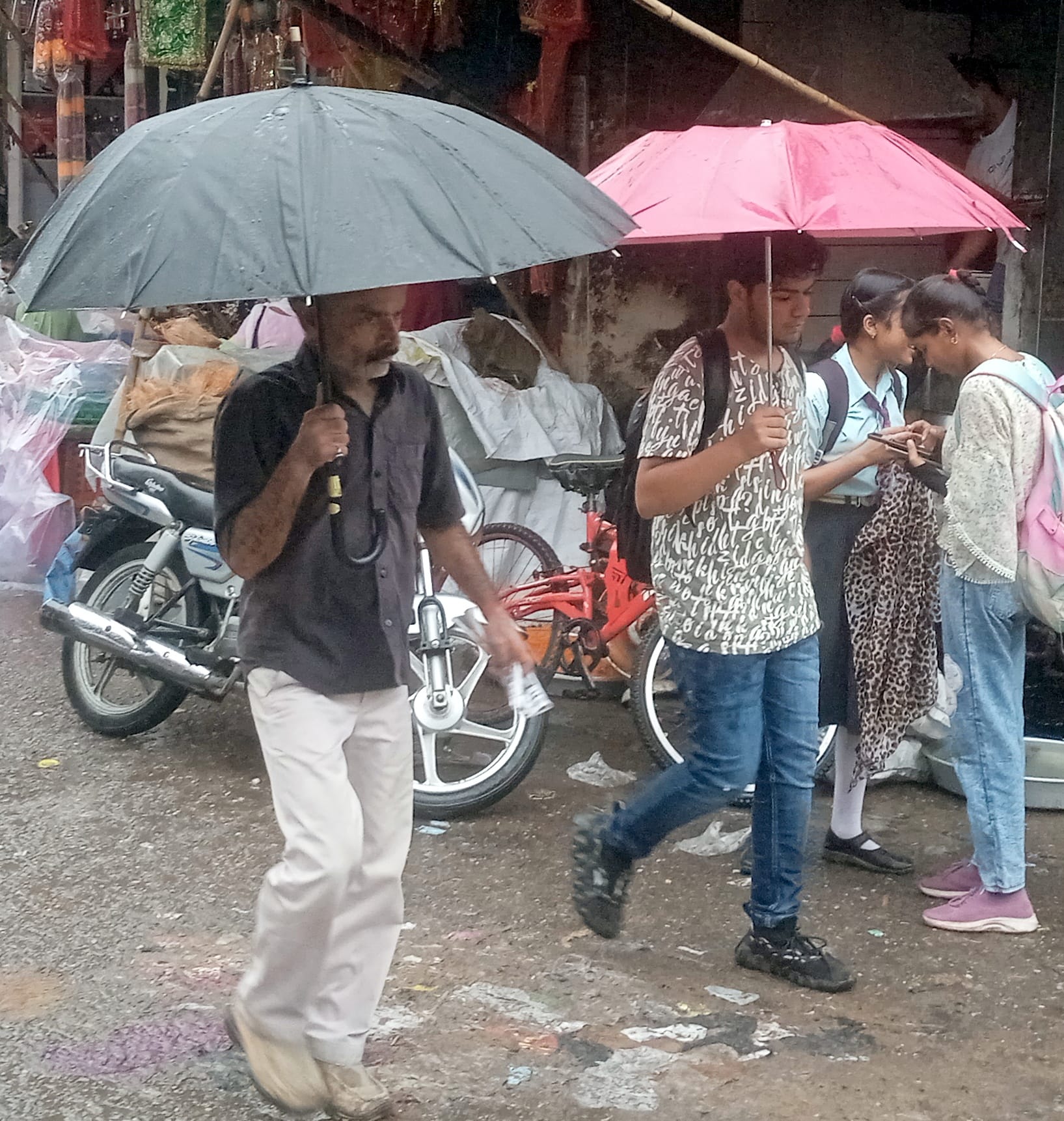 शामली में छाता लगा कर गुजरते युवक।