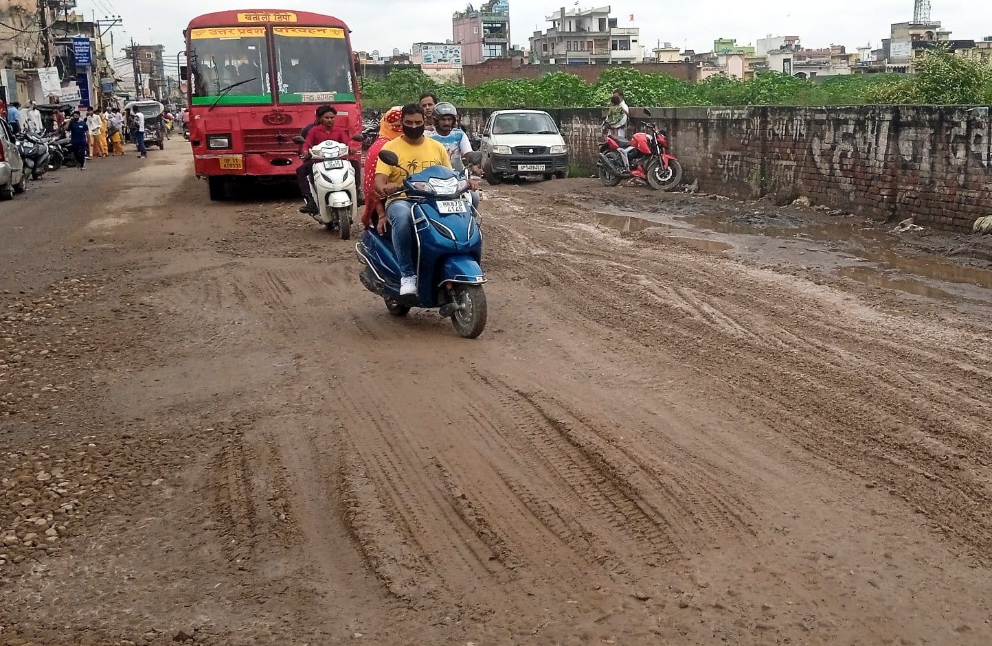 शामली मे मेरठ-करनाल हाईवे पर गड्ढे भरने के लिए बिछाई गई रोड़ी व मिट्टी से गुजरते वाहन।