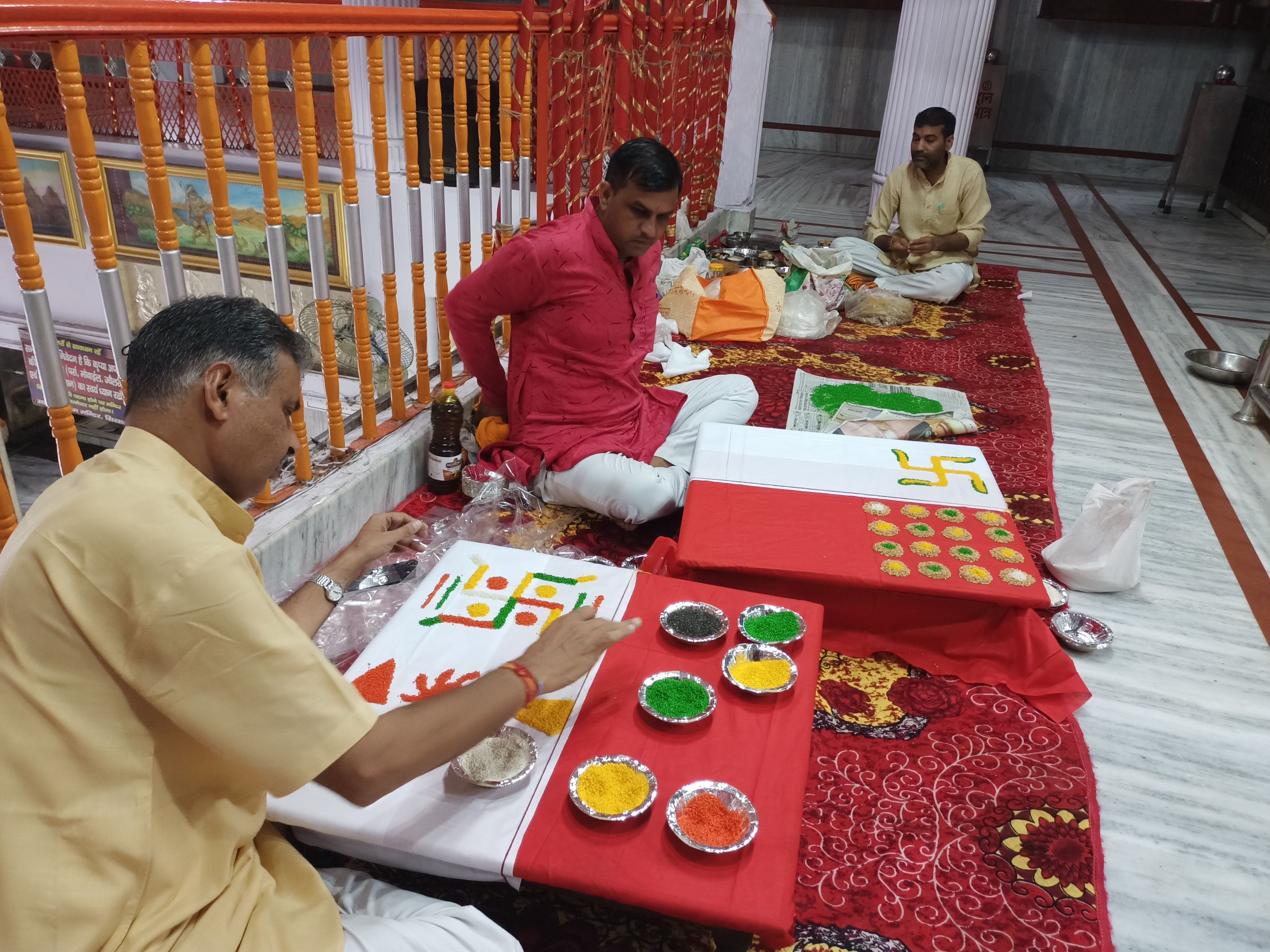शहर के सालासर धाम मंदिर में ग्रहों की रंगोली बनाते पंडित। संवाद शहर के सालासर धाम मंदिर में ग्रहों की रंगोली बनाते पंडित। संवाद