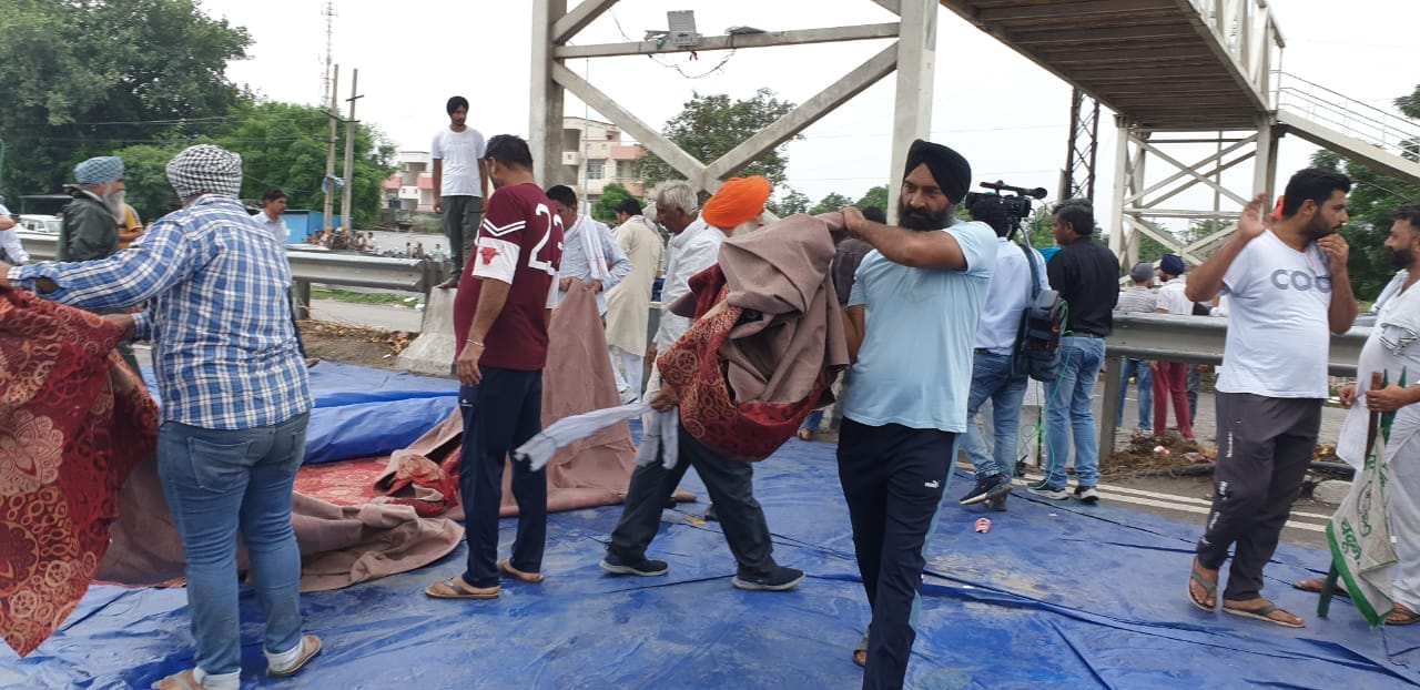  धरना सामप्ति की घोषणा के बाद सड़क से सामान उठाते किसान।  संवाद