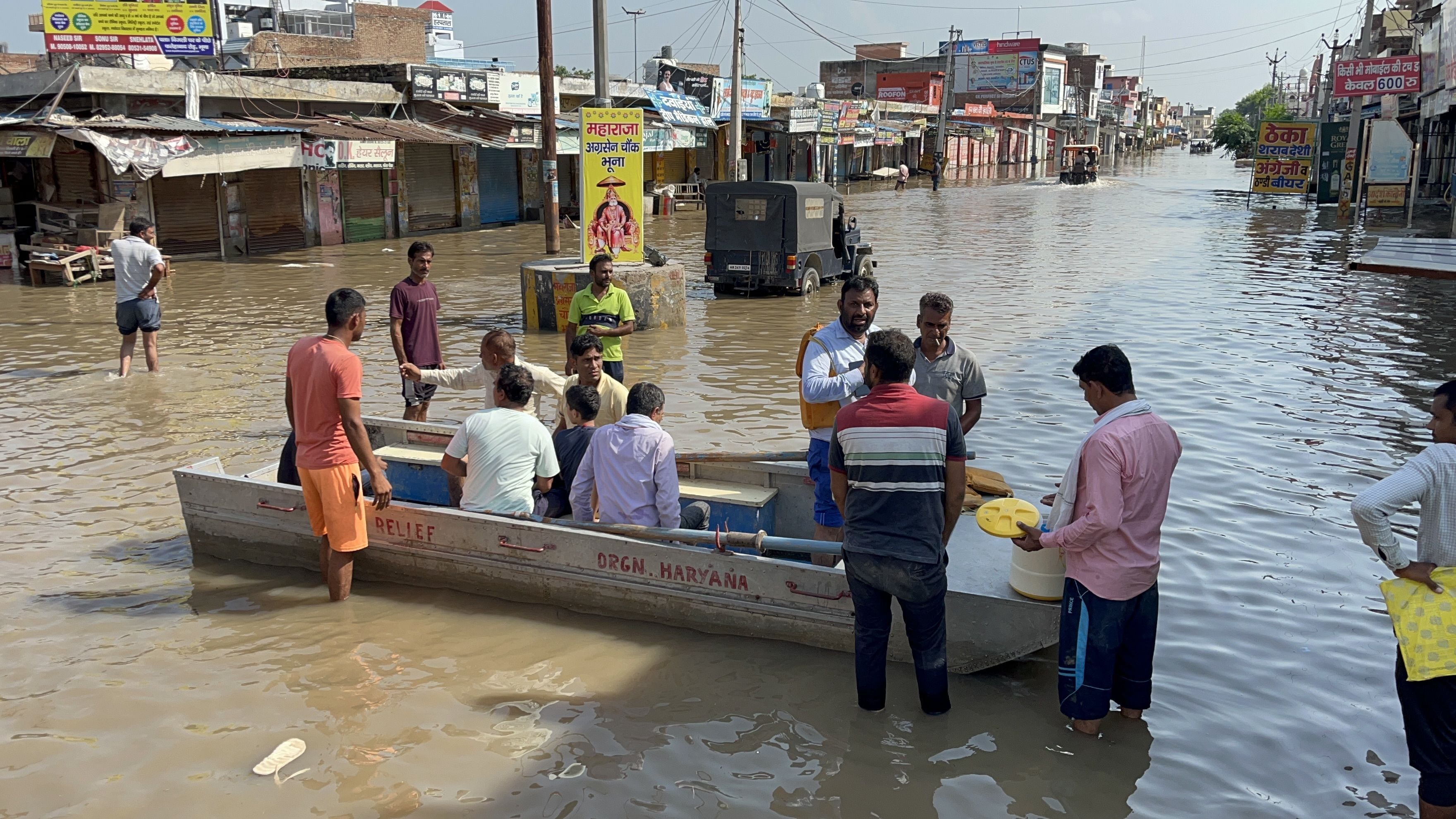 भूना में लोगों को किश्तियों पर बैठाकर ले जाते कर्मचारी। भूना में लोगों को किश्तियों पर बैठाकर ले जाते कर्मचारी।