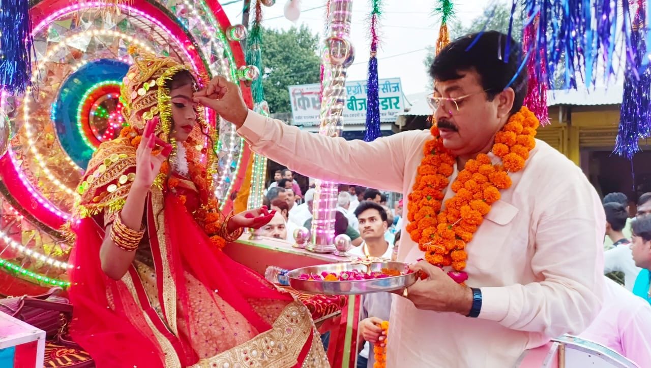 रथ पर सवार देवी के रुप में बैठी कन्या को तिलक लगाकर पूजा करते समाजसेवी लालजी शुक्ला। संवाद