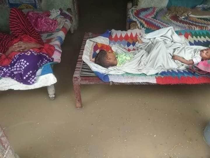 हिसार। राजली गांव में घर के अंदर घुसे पानी के अंदर चारपाई पर सोते बच्चे।