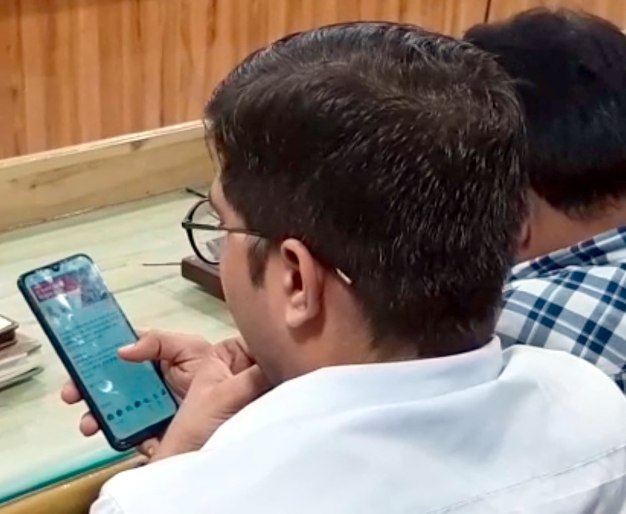 शामली कलक्ट्रेट सभागार में संपूर्ण समाधान दिवस के दौरान मोबाइल में व्यस्त अधिकारी।