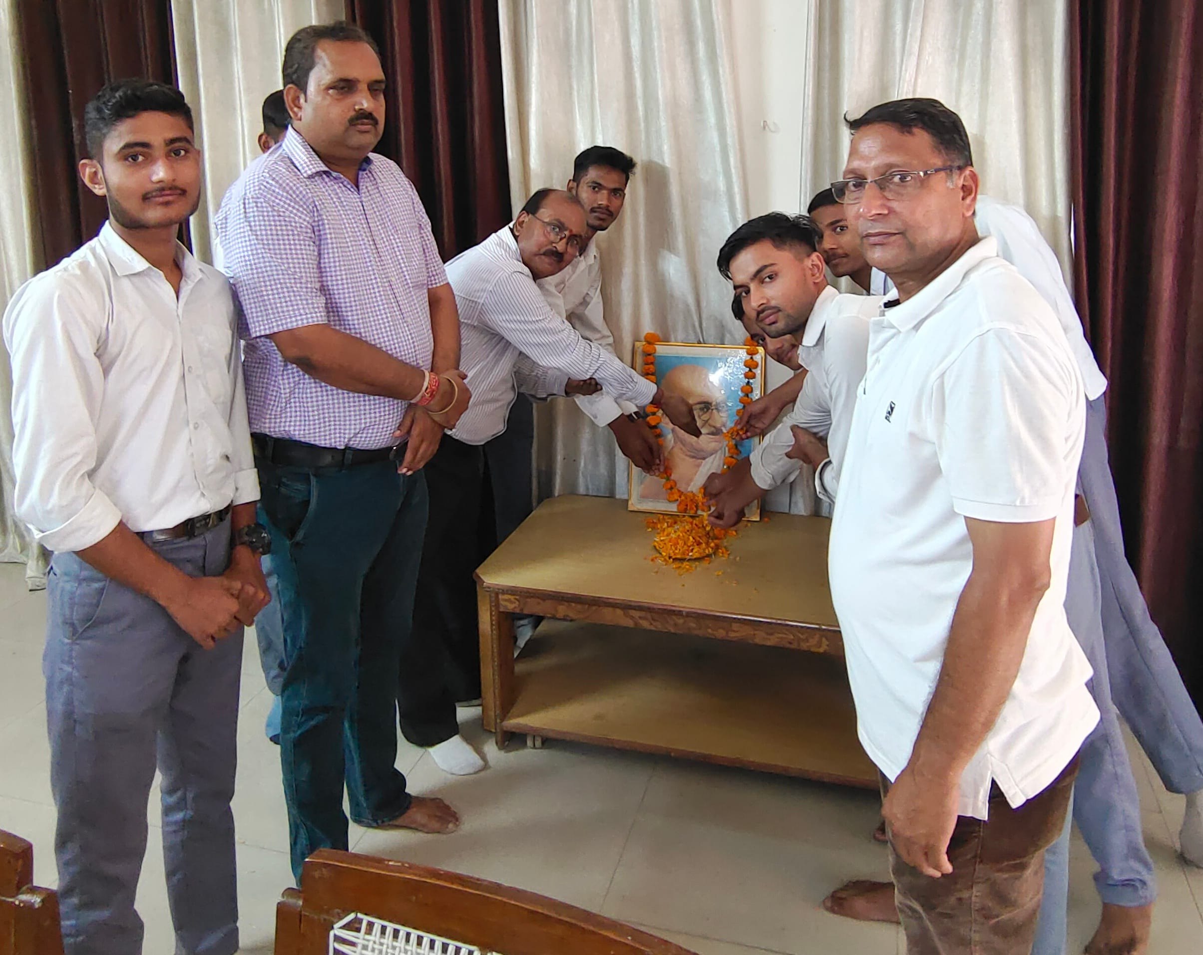 शामली वीवी इंटर कॉलेज में महात्मा गांधी के चित्र पर पुष्प अर्पित करते शिक्षक।