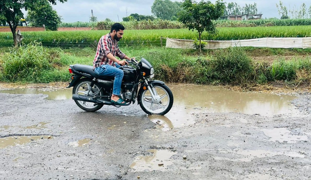 कांधला-बुढ़ाना मार्ग की खस्ताहाल सड़क से गुजरता बाइक सवार।