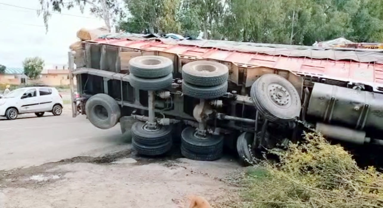ट्राली को टक्कर मारने के बाद हाईवे पर पलटा ट्रक।  संवाद