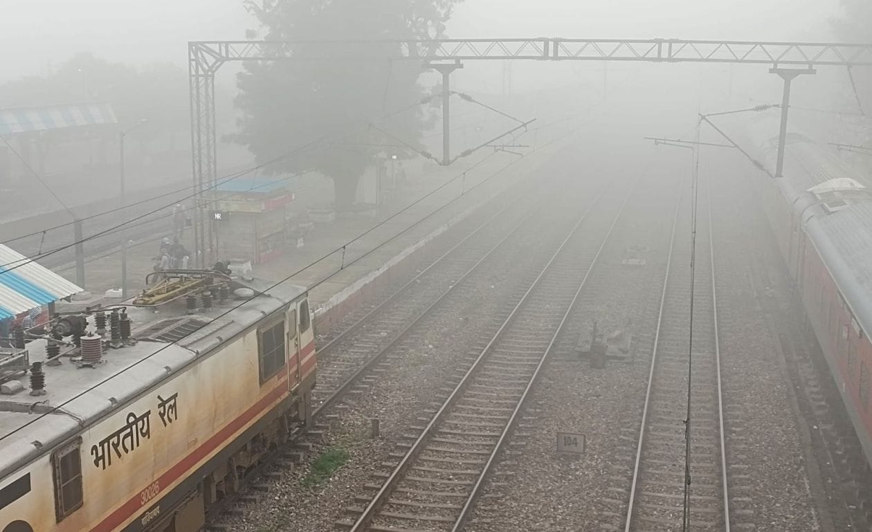 रेलवे स्टेशन पर सुबह के समय छायी धुंध में प्लेटफार्म पर खडी ट्रेन । संवाद रेलवे स्टेशन पर सुबह के समय छायी धुंध में प्लेटफार्म पर खडी ट्रेन । संवाद