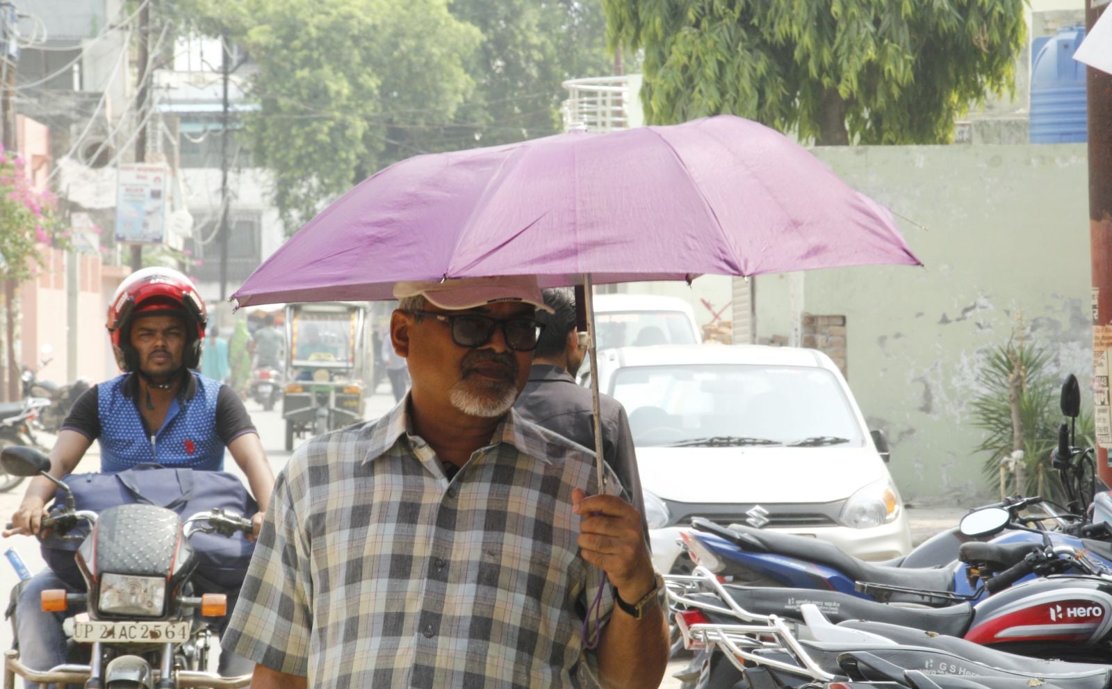 बारिश के बाद निकली तेज में भी छाता लेकर निकले लोग। धूप संवाद बारिश के बाद निकली तेज में भी छाता लेकर निकले लोग। धूप संवाद