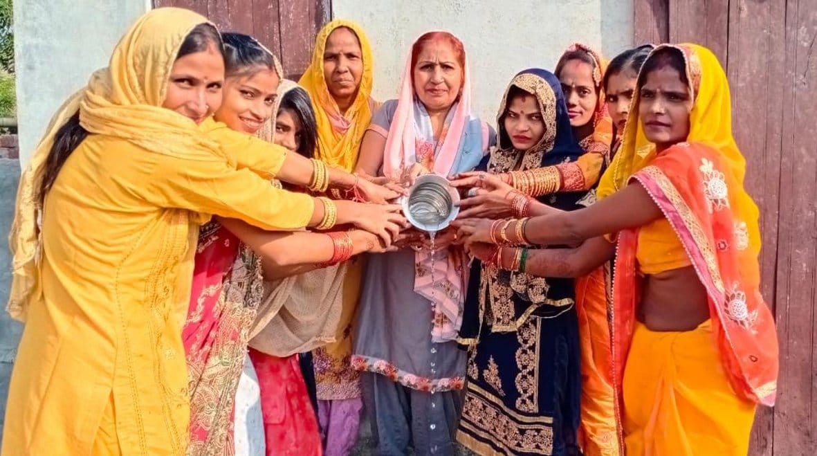 किशनपुर बराल में भगवान सूर्य को जल देती महिलाएं