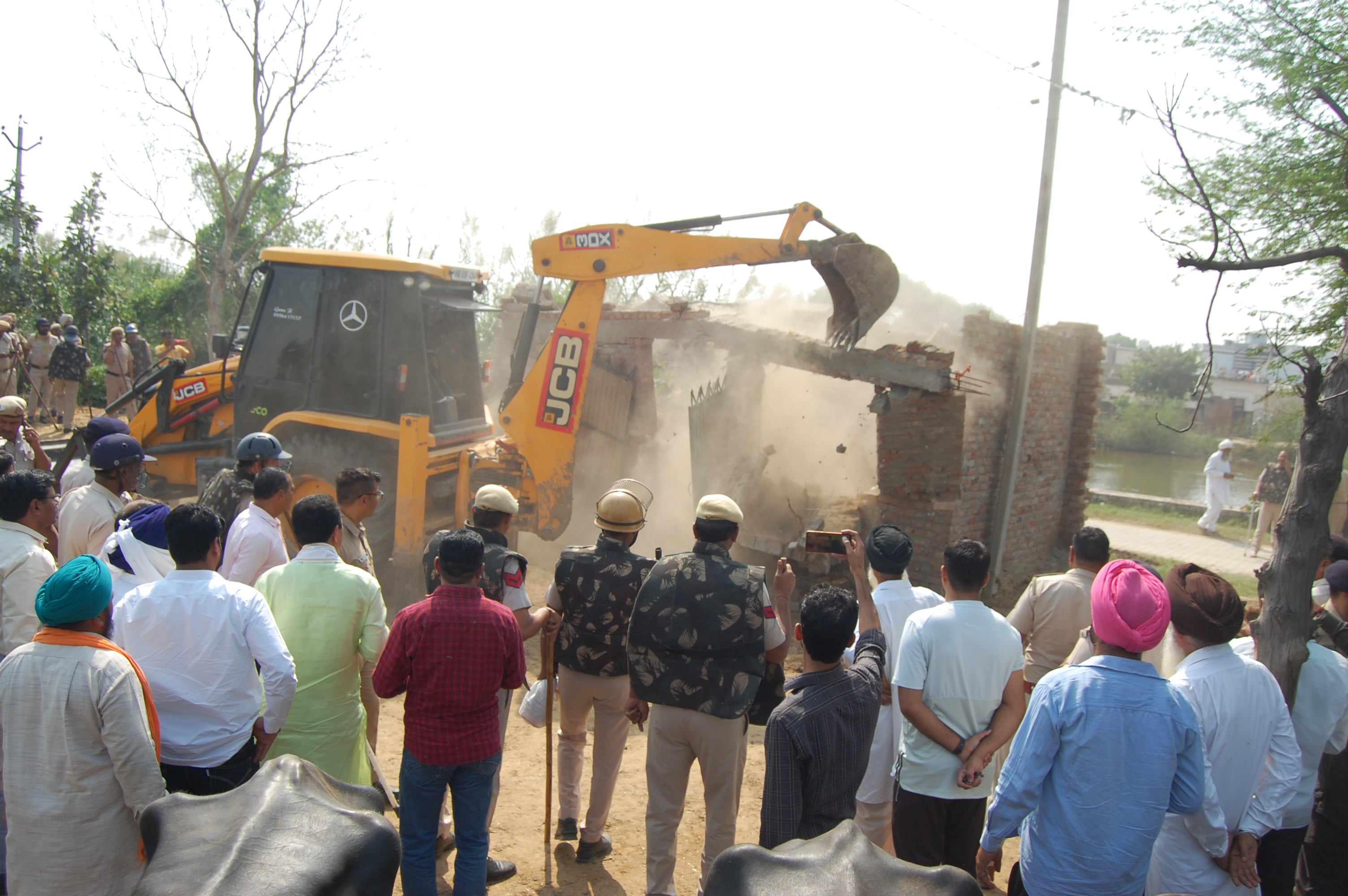 22-कैथल। गांव दाबन खेड़ी में पुलिस बल की मौजूदगी में जेसीबी मशीन द्वारा पशु बाड़ा गिरवाते हुए प्रश?