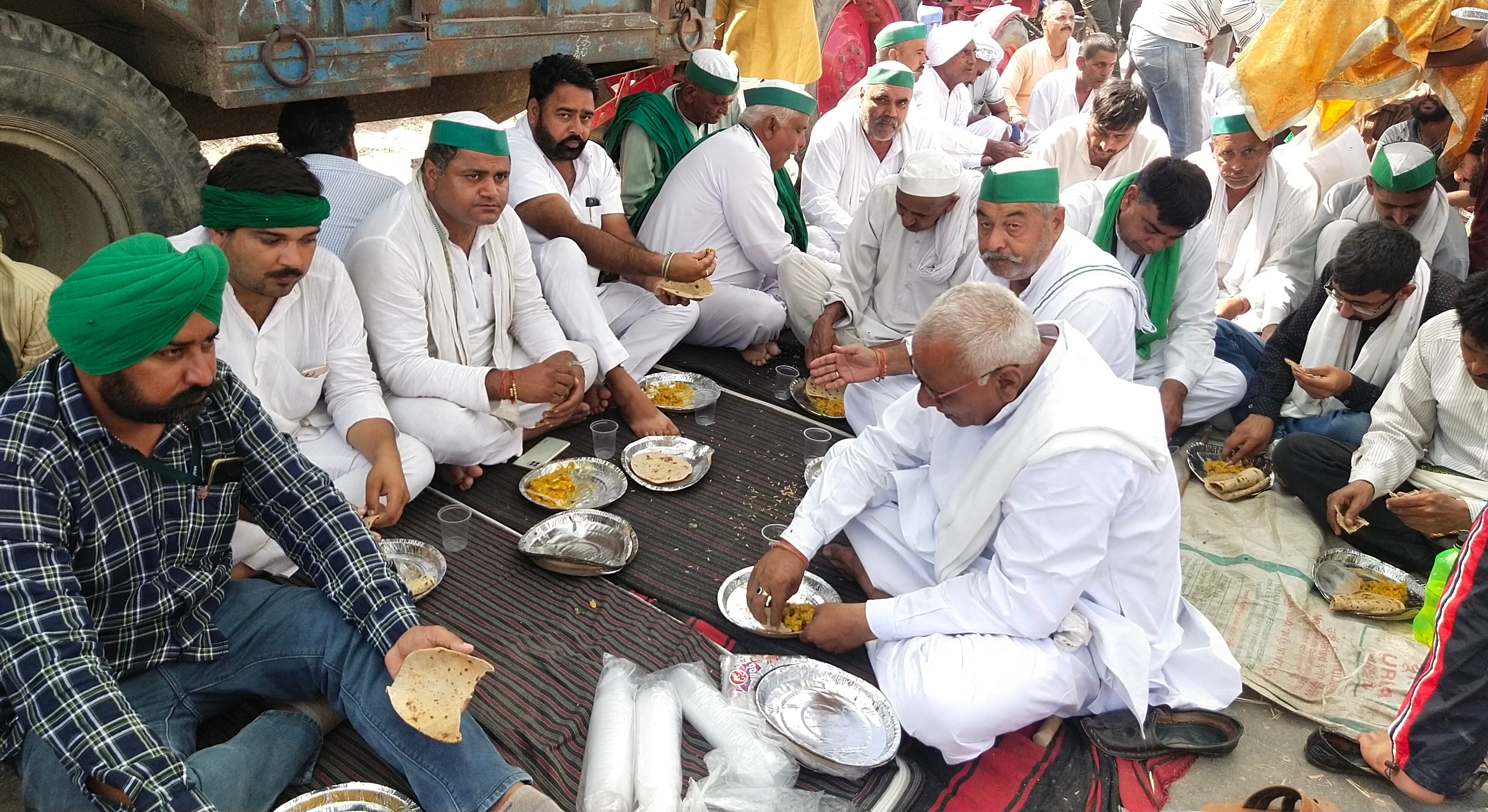 धरने के दौरान दोपहर का भोजन करते भाकियू के कार्यकर्ता। धरने के दौरान दोपहर का भोजन करते भाकियू के कार्यकर्ता।