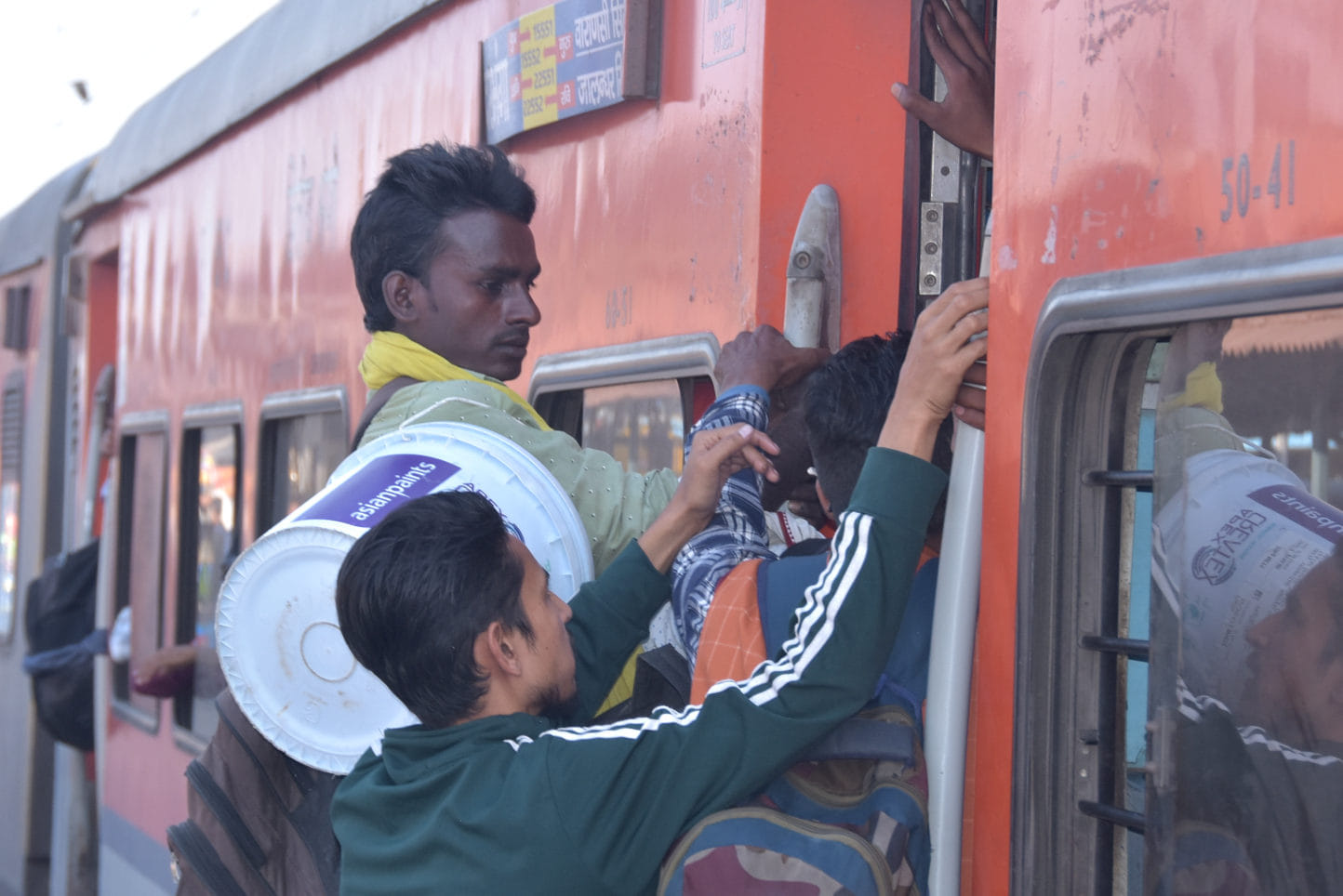 ट्रेन में लटककर जाते यात्री। ट्रेन में लटककर जाते यात्री।