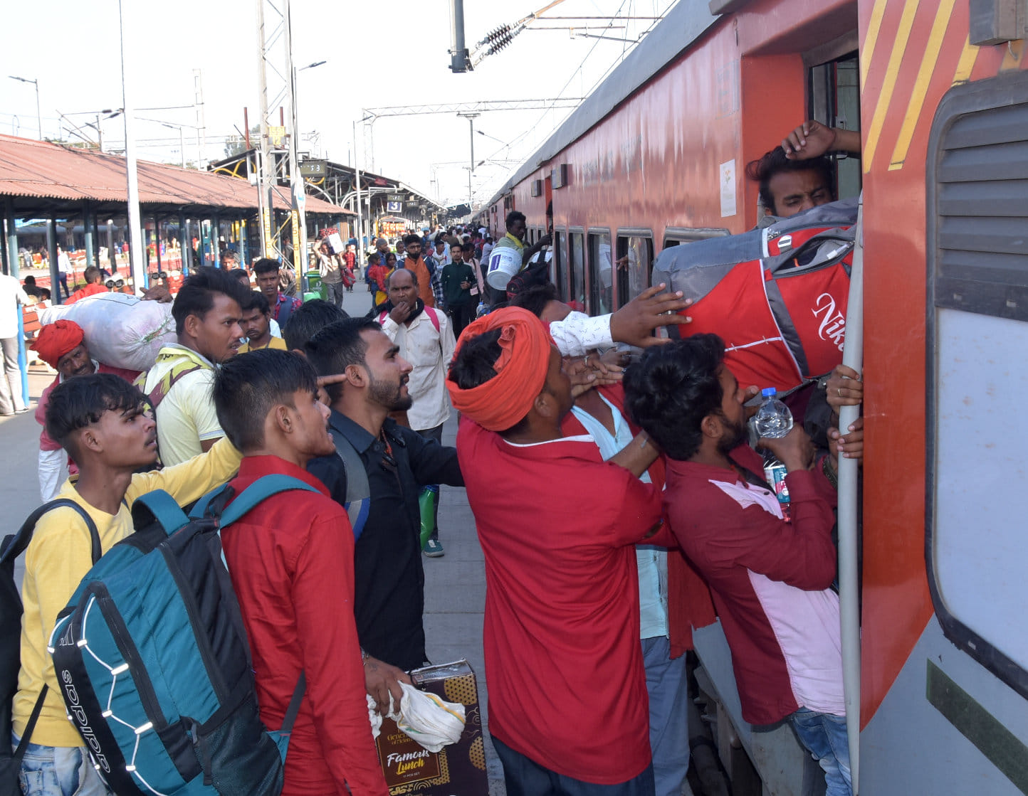 ट्रेन में यात्रियों को चढ़ाते कुली। ट्रेन में यात्रियों को चढ़ाते कुली।