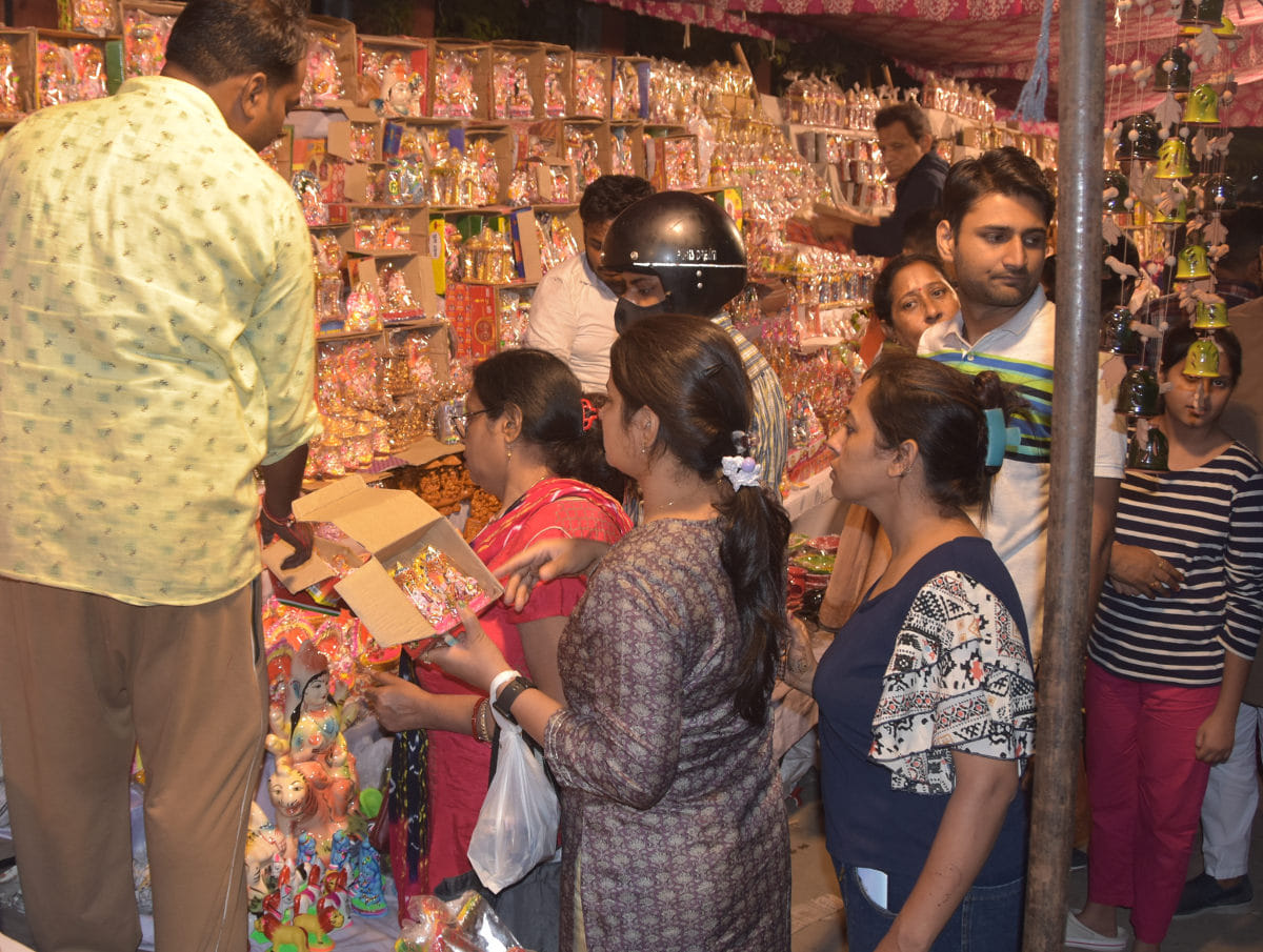 दीपावली पूजन के लिये मूर्तिया खरीदते लोग दीपावली पूजन के लिये मूर्तिया खरीदते लोग