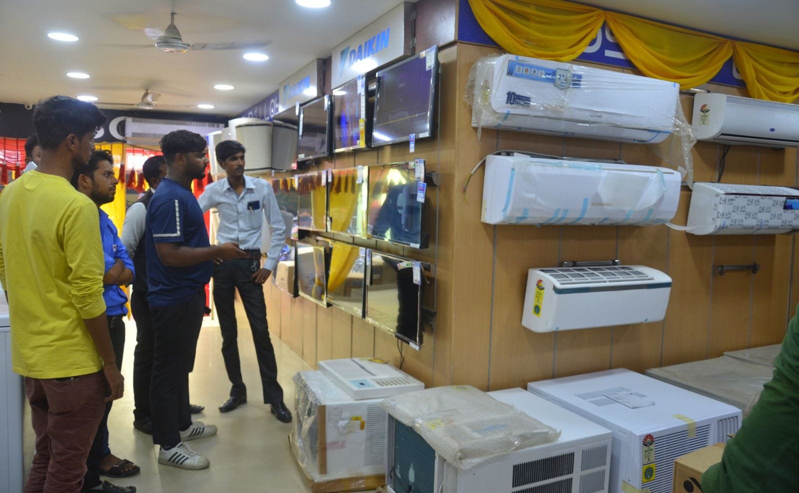 इलेक्ट्रॉनिक्स की दुकान पर खरीदारी करते लोग। संवाद इलेक्ट्रॉनिक्स की दुकान पर खरीदारी करते लोग। संवाद