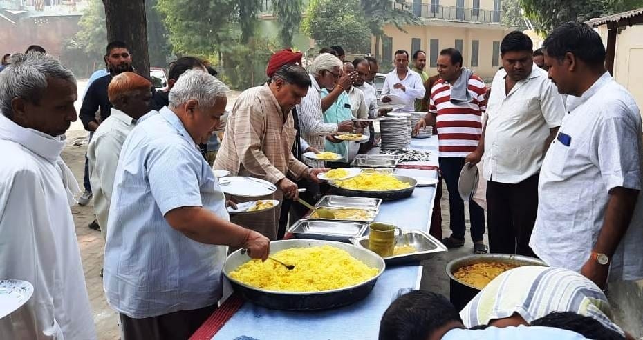गंगोह में अन्नकूट पर्व में प्रसाद पाते श्रद्धालुजन