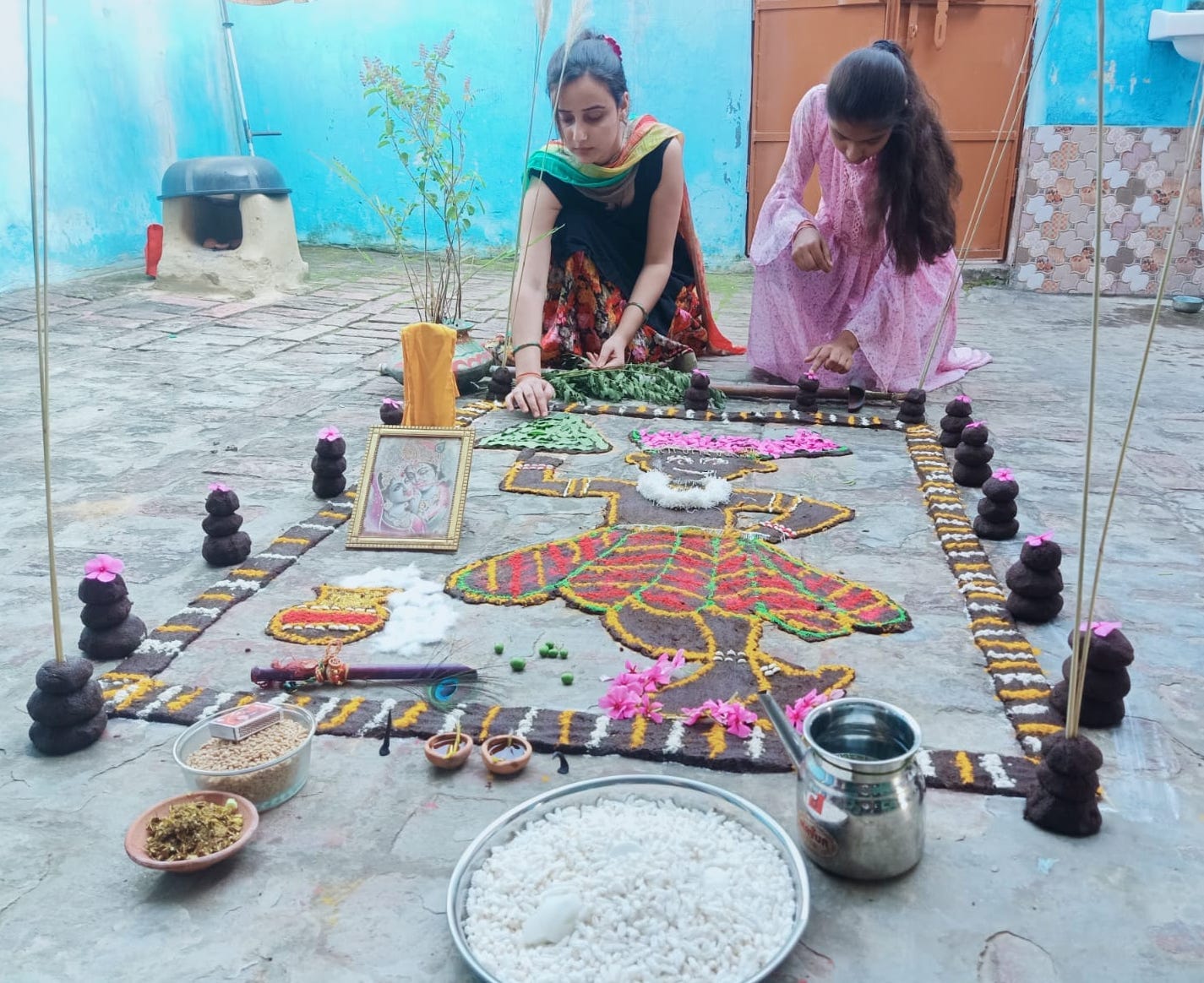 मंडावली में गोबर से गोवर्धन बनातीं युवतियां।