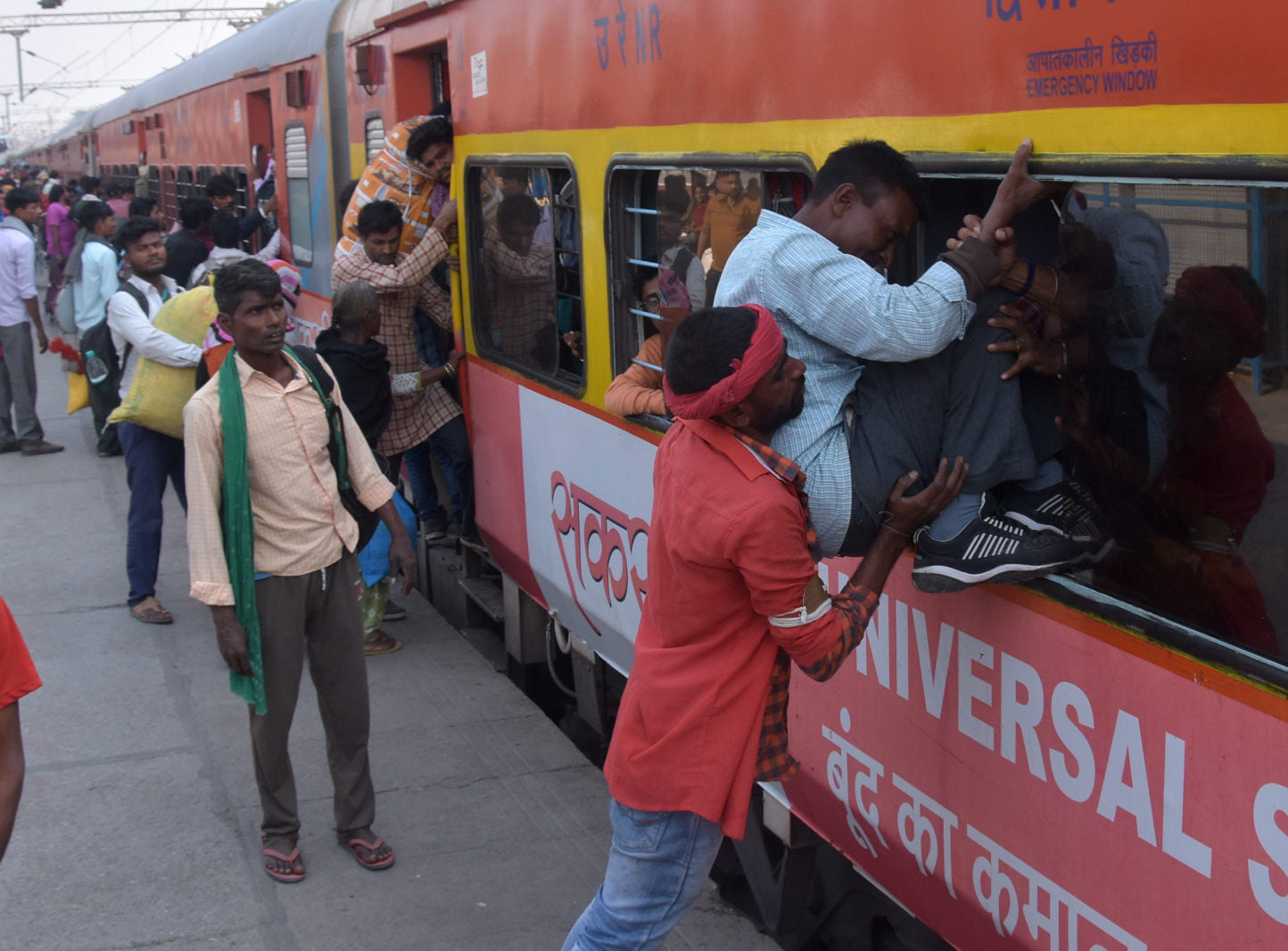 भाईदूज और छठ के चलते रेलवे स्टेशन पर ट्रेन में सवारी को चढ़ता कुली भाईदूज और छठ के चलते रेलवे स्टेशन पर ट्रेन में सवारी को चढ़ता कुली