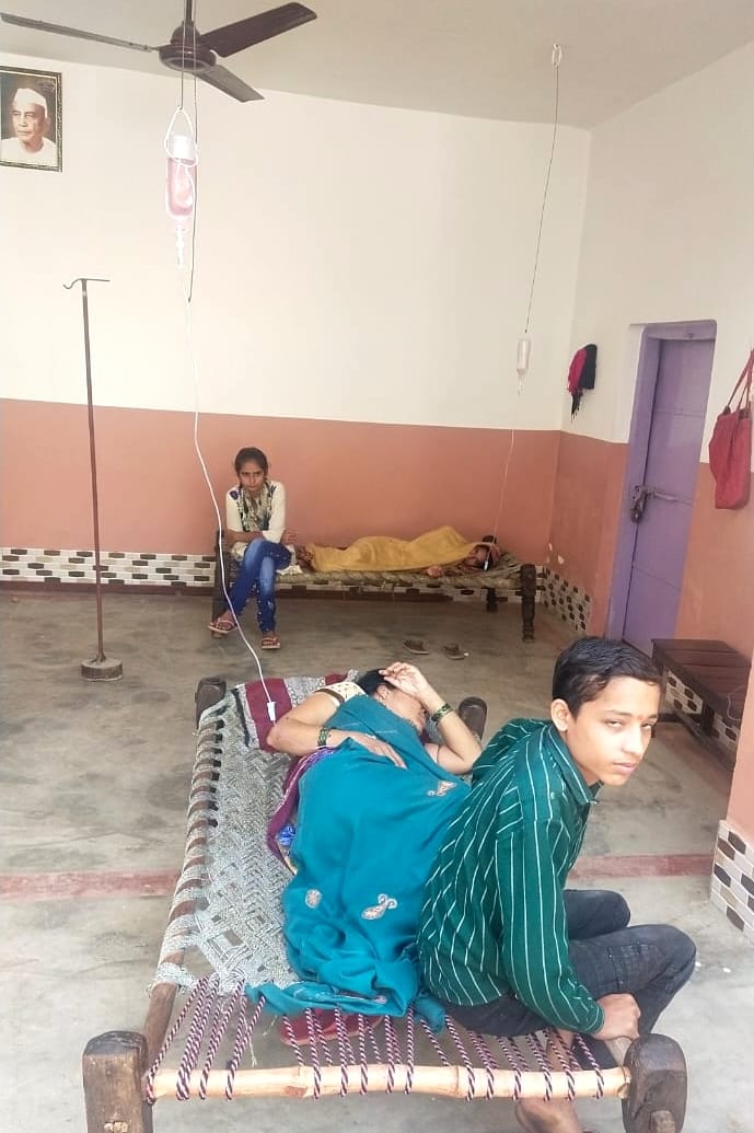 किरतपुर के गांव बहुपुरा में पंखे में बांधकर बुखार से पीड़ित महिला को लगती ड्रिप। किरतपुर के गांव बहुपुरा में पंखे में बांधकर बुखार से पीड़ित महिला को लगती ड्रिप।
