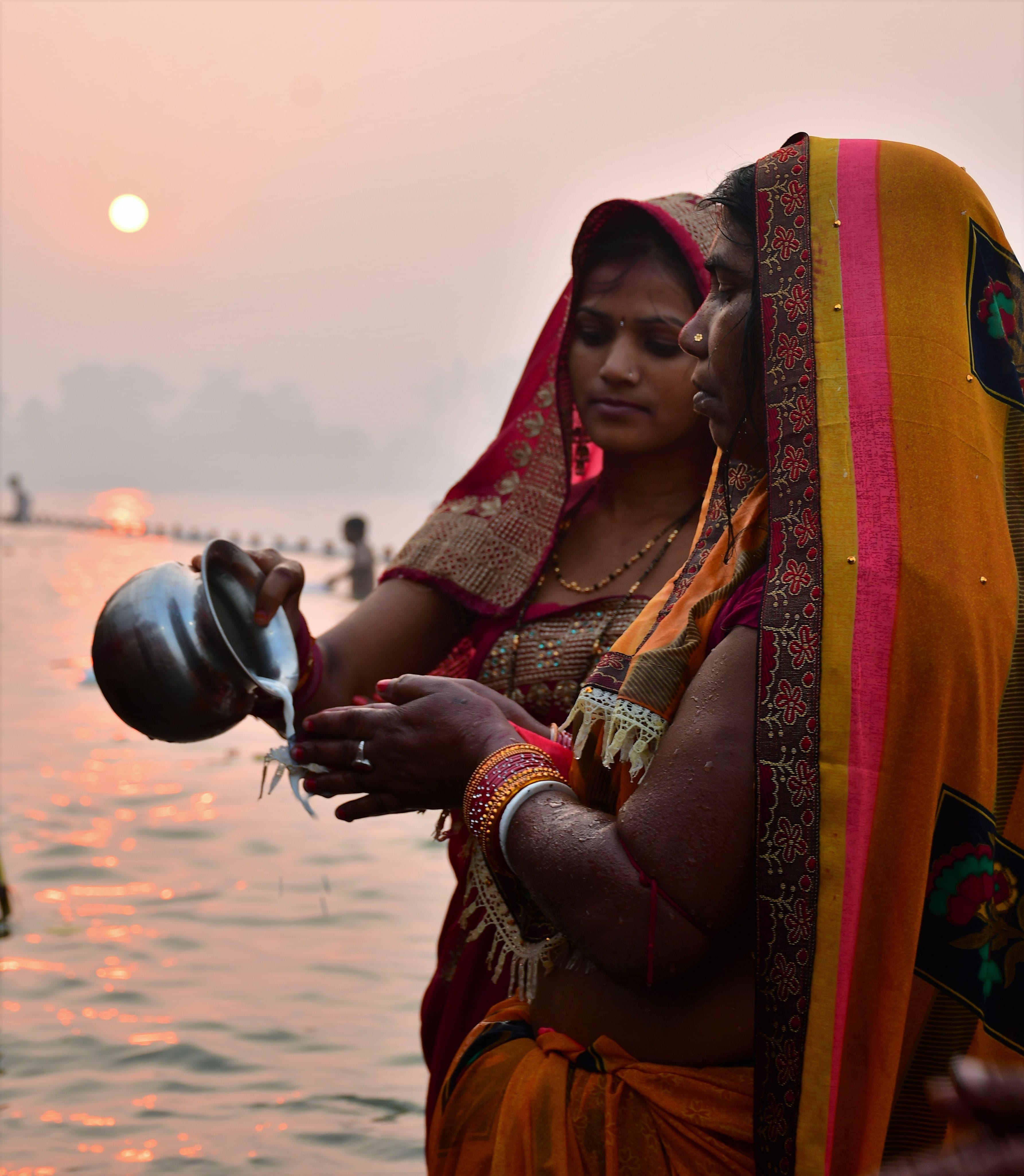 उगते सूर्य को अर्घ्य देती महिला। संवाद उगते सूर्य को अर्घ्य देती महिला। संवाद