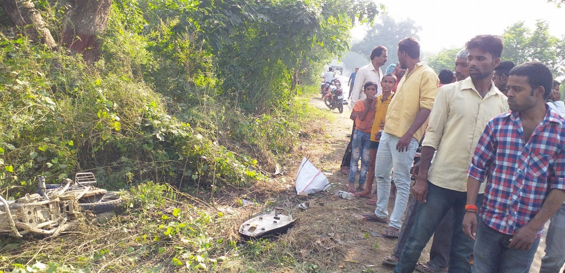 कादरचौक-बदायूं रोड पर सड़क किनारे पड़ी बाइक देखते राहगीर। संवाद कादरचौक-बदायूं रोड पर सड़क किनारे पड़ी बाइक देखते राहगीर। संवाद