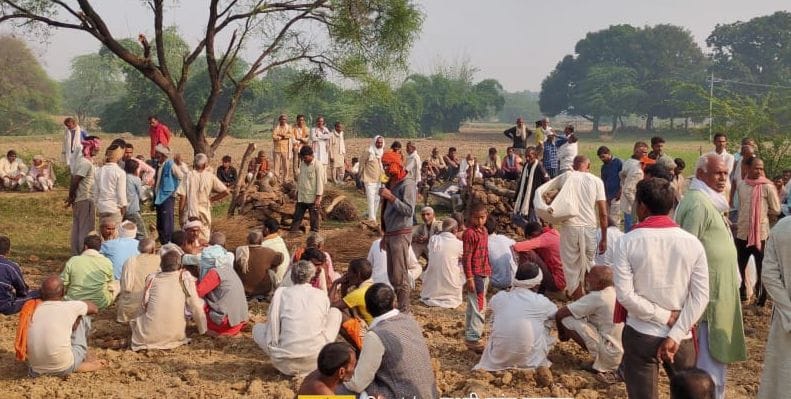 अंतिम संस्कार के दौरान खेत में मौजूद शोकग्रस्त परिजन और ग्रामीण।