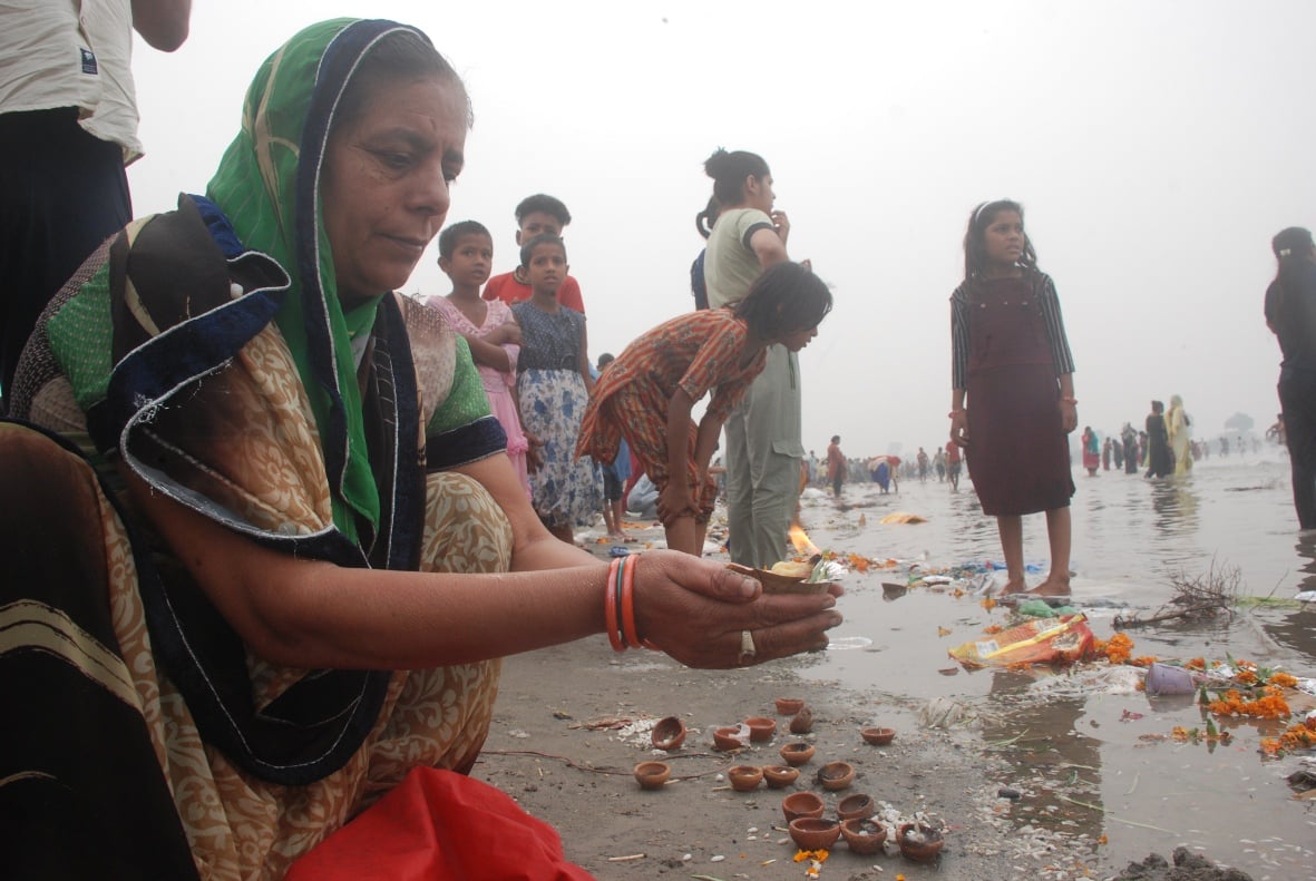 बागपत यमुना में स्नान के दौरान दीपदान करती महिला श्रद्घालु बागपत यमुना में स्नान के दौरान दीपदान करती महिला श्रद्घालु