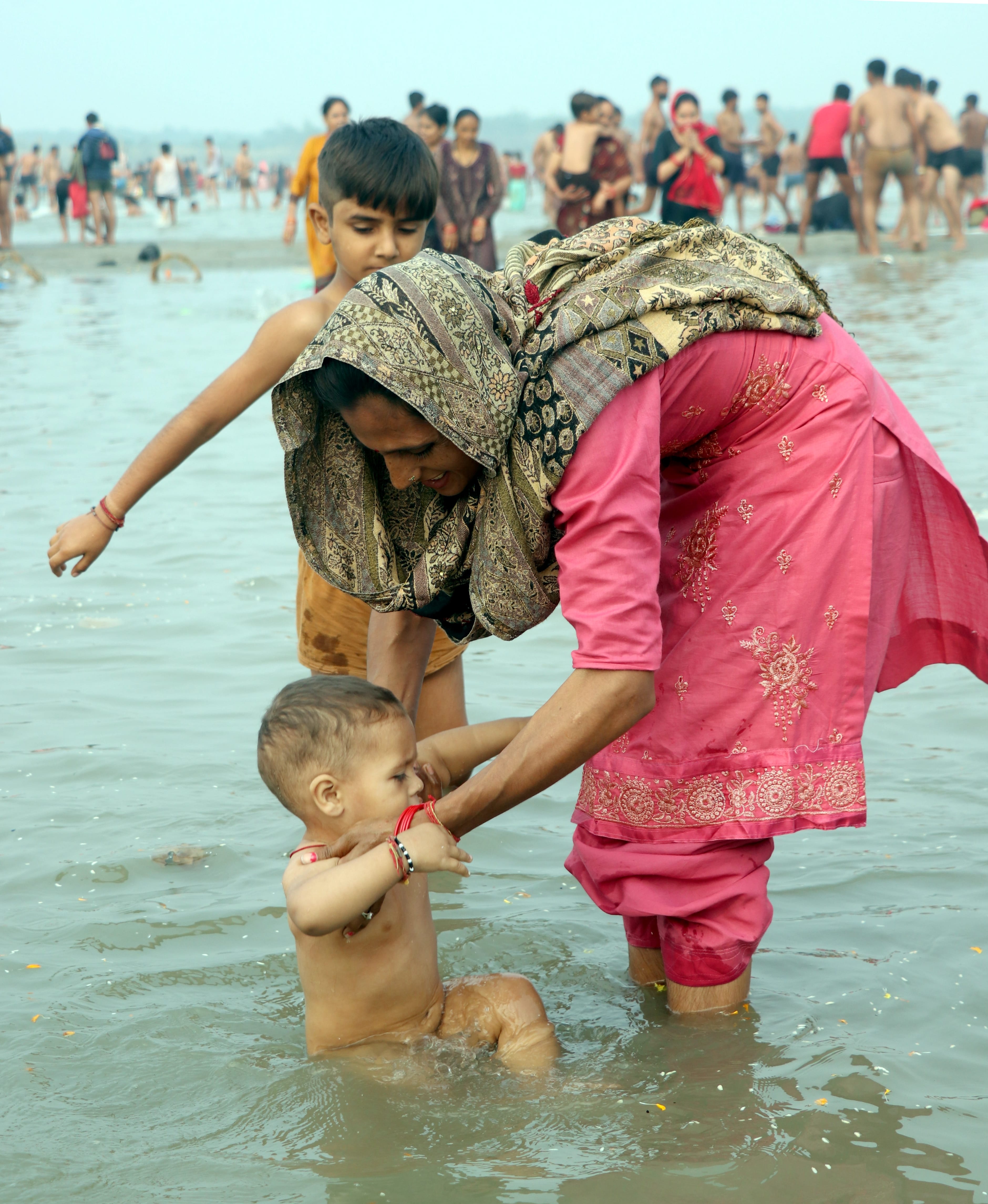 बिजनौर में विदुर कुटी के सामने गंगा स्नान मेले में गंगा में अपने बच्चे को स्नान कराती महिला। बिजनौर में विदुर कुटी के सामने गंगा स्नान मेले में गंगा में अपने बच्चे को स्नान कराती महिला।