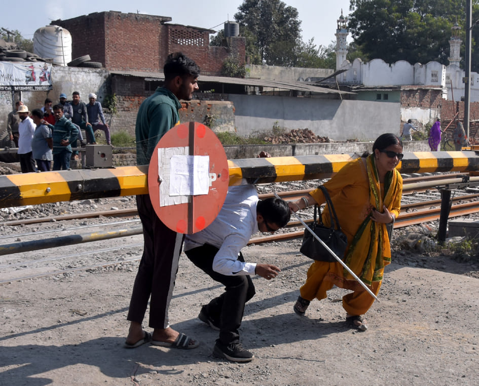 फाटक बंद होने के कारण पैदल निकलते लोग फाटक बंद होने के कारण पैदल निकलते लोग