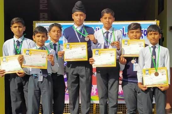 गंगोह के नामदेव पब्लिक स्कूल में मेडल और प्रमाणपत्र दिखाते विजेता विद्यार्थी