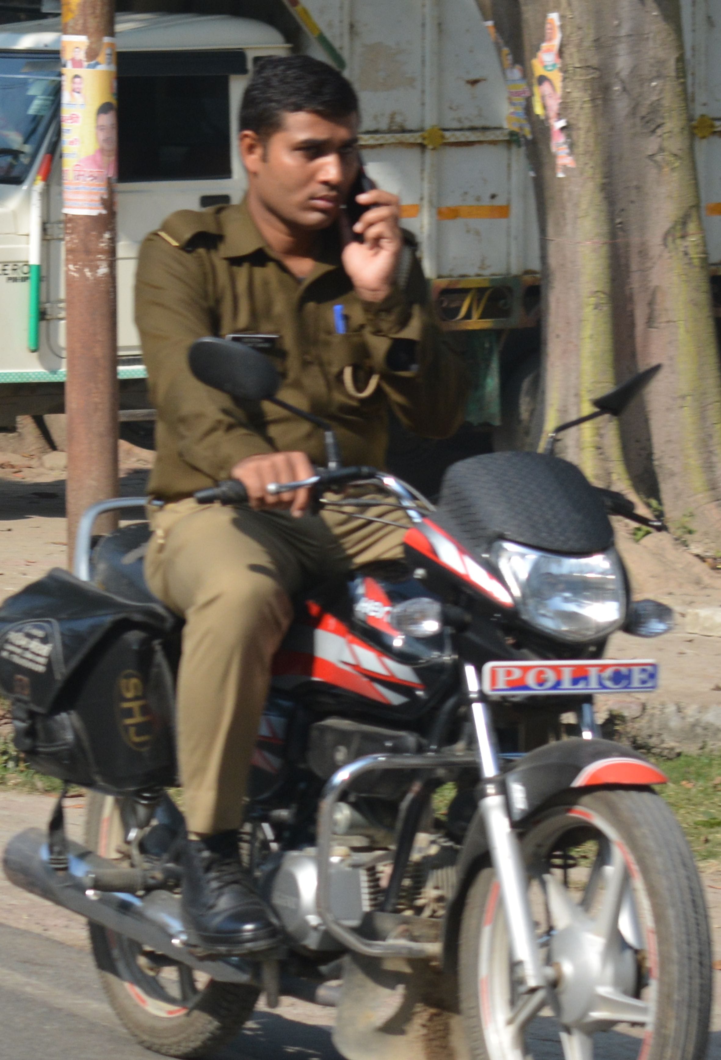 फोटो-15- स्टेशन रोड पर मोबाइल पर बात करते जा रहा पुलिस कर्मी। फोटो-15- स्टेशन रोड पर मोबाइल पर बात करते जा रहा पुलिस कर्मी।