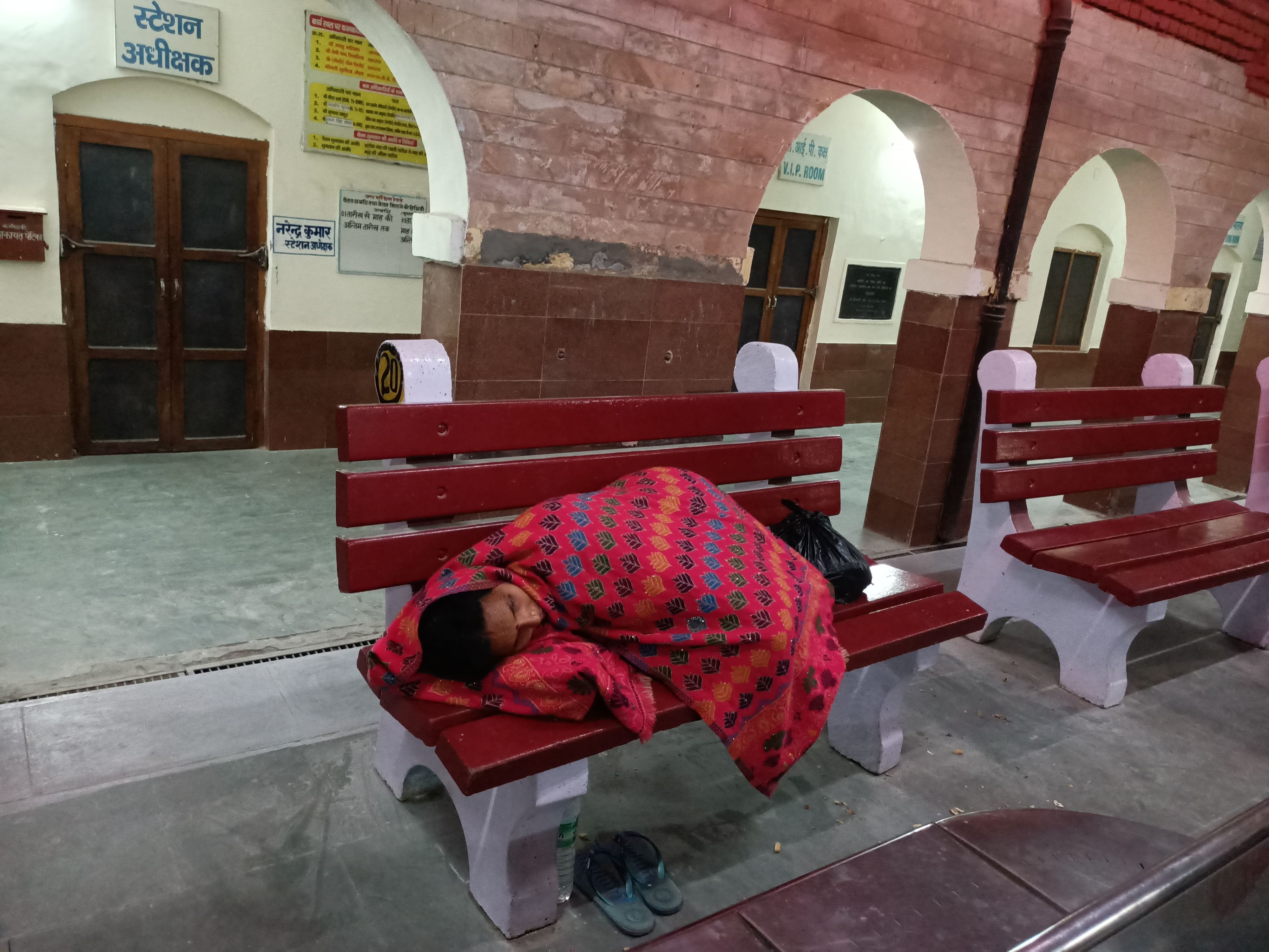 रात्रि के समय रेलवे स्टेशन पर विश्राम करती महिला यात्री। संवाद रात्रि के समय रेलवे स्टेशन पर विश्राम करती महिला यात्री। संवाद