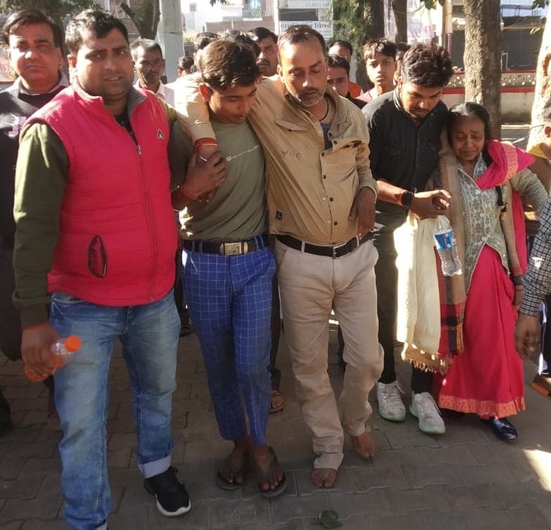 पीड़ित दुकानदार को ले जाते लोग।