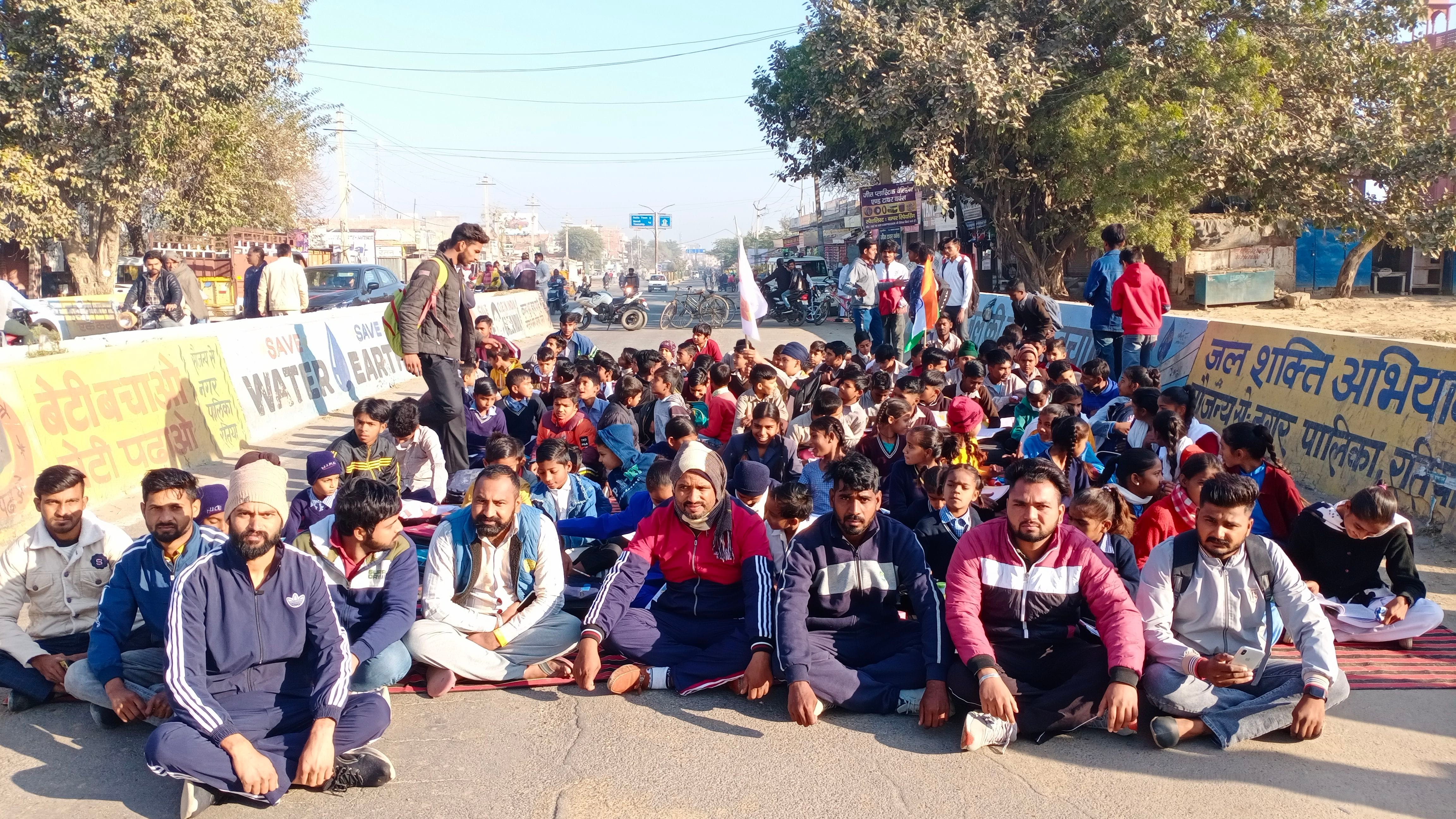 तिया में पुल के रास्ते पर बैठ कर रोड जाम करते कॉलोनीवासी। तिया में पुल के रास्ते पर बैठ कर रोड जाम करते कॉलोनीवासी।