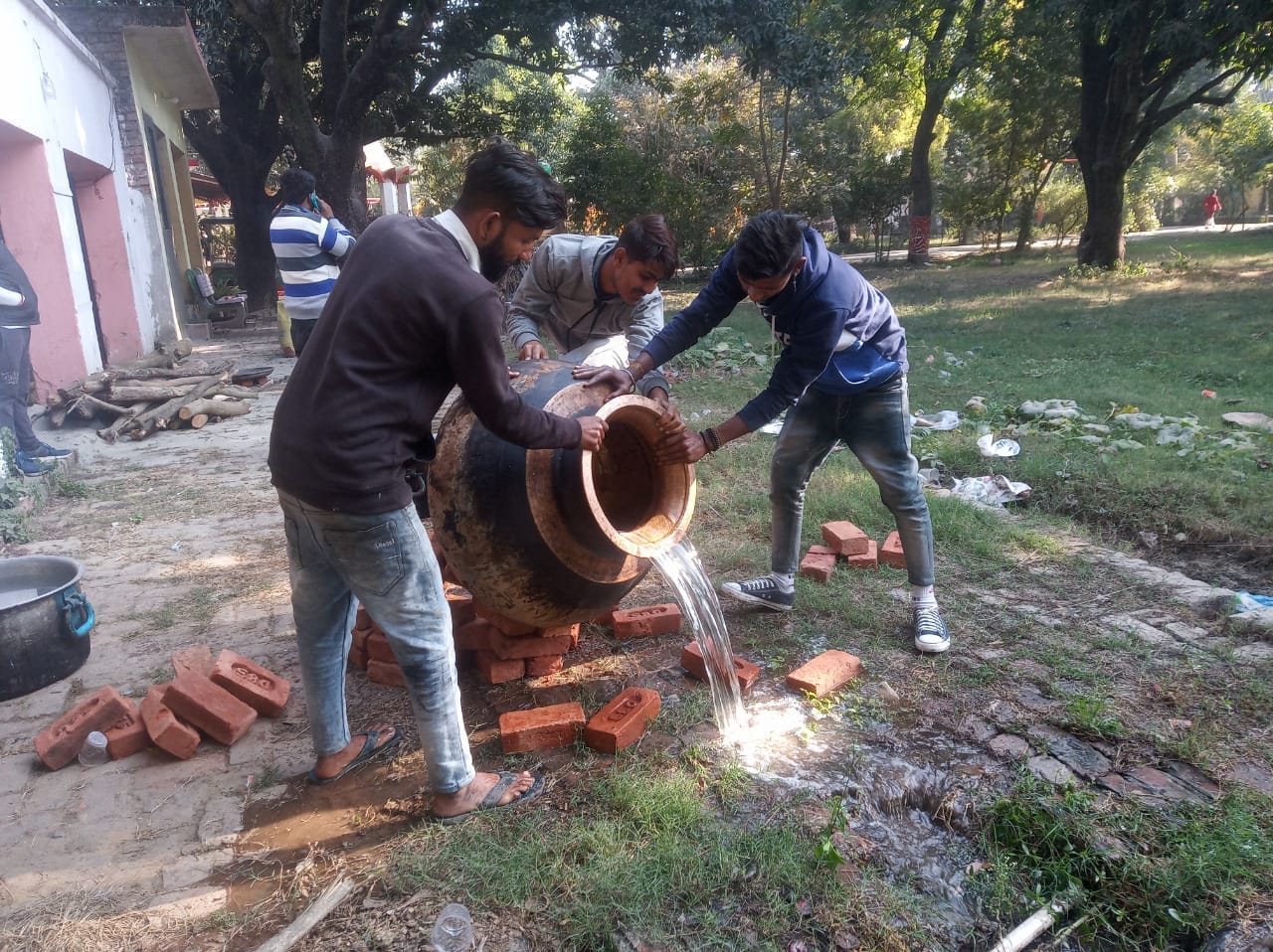 उड़द बनाने के लिए ढैग में उबल रहे पानी को बिखेरते कारीगर उड़द बनाने के लिए ढैग में उबल रहे पानी को बिखेरते कारीगर