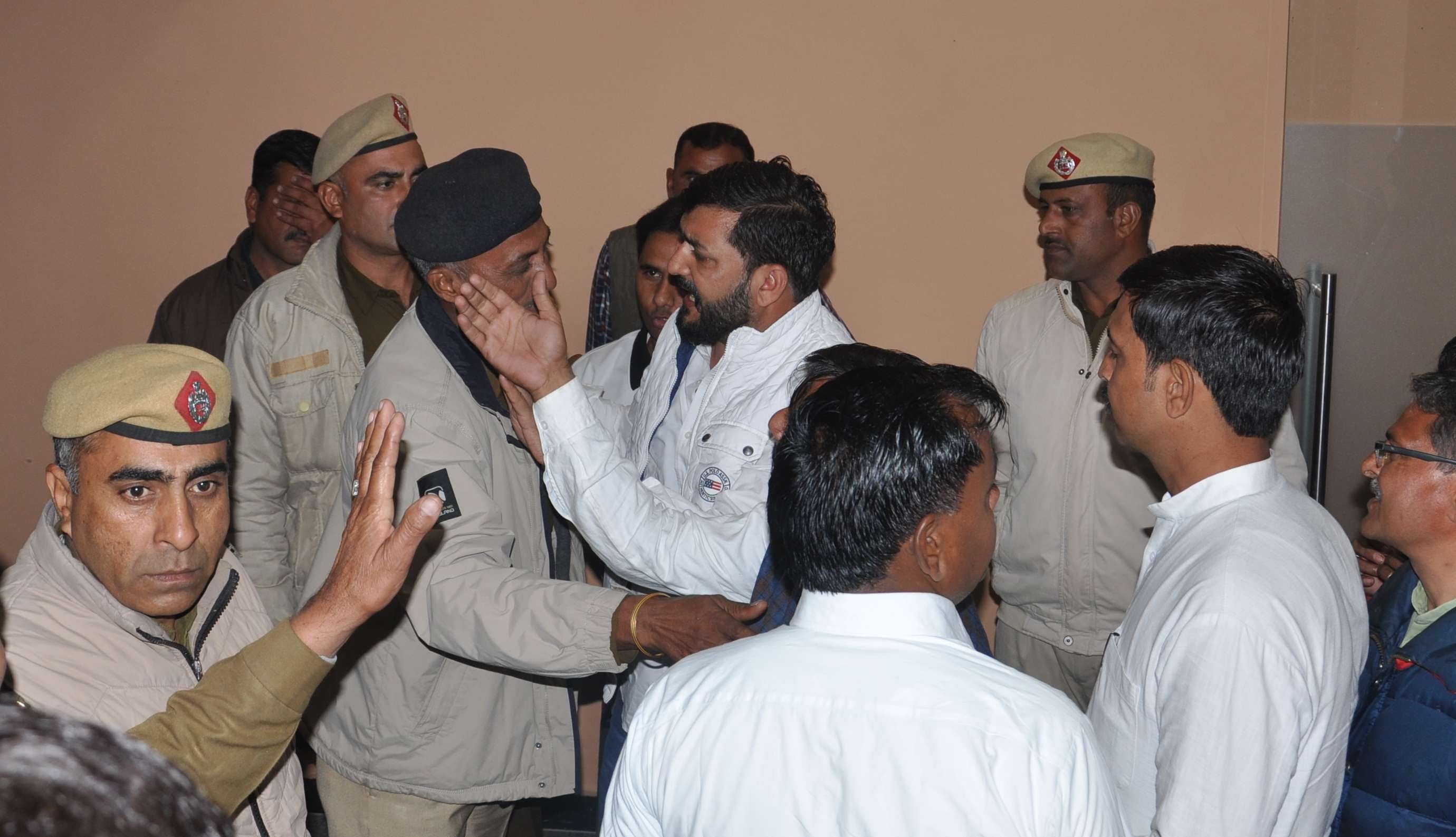 हिसार। सरपंच को अंदर जाने से रोकता पुलिस कर्मचारी।