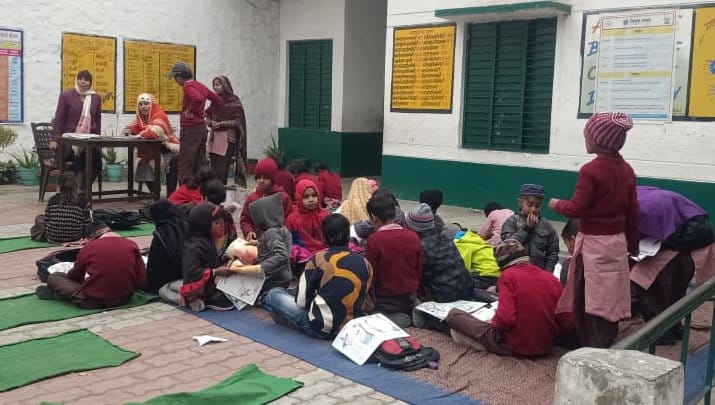 गढ़ीपुख्ता स्थित प्राइमरी विद्यालय नंबर एक में कड़ाके की सर्दी खुले में बैठकर पढ़ाई करते बच्चे।