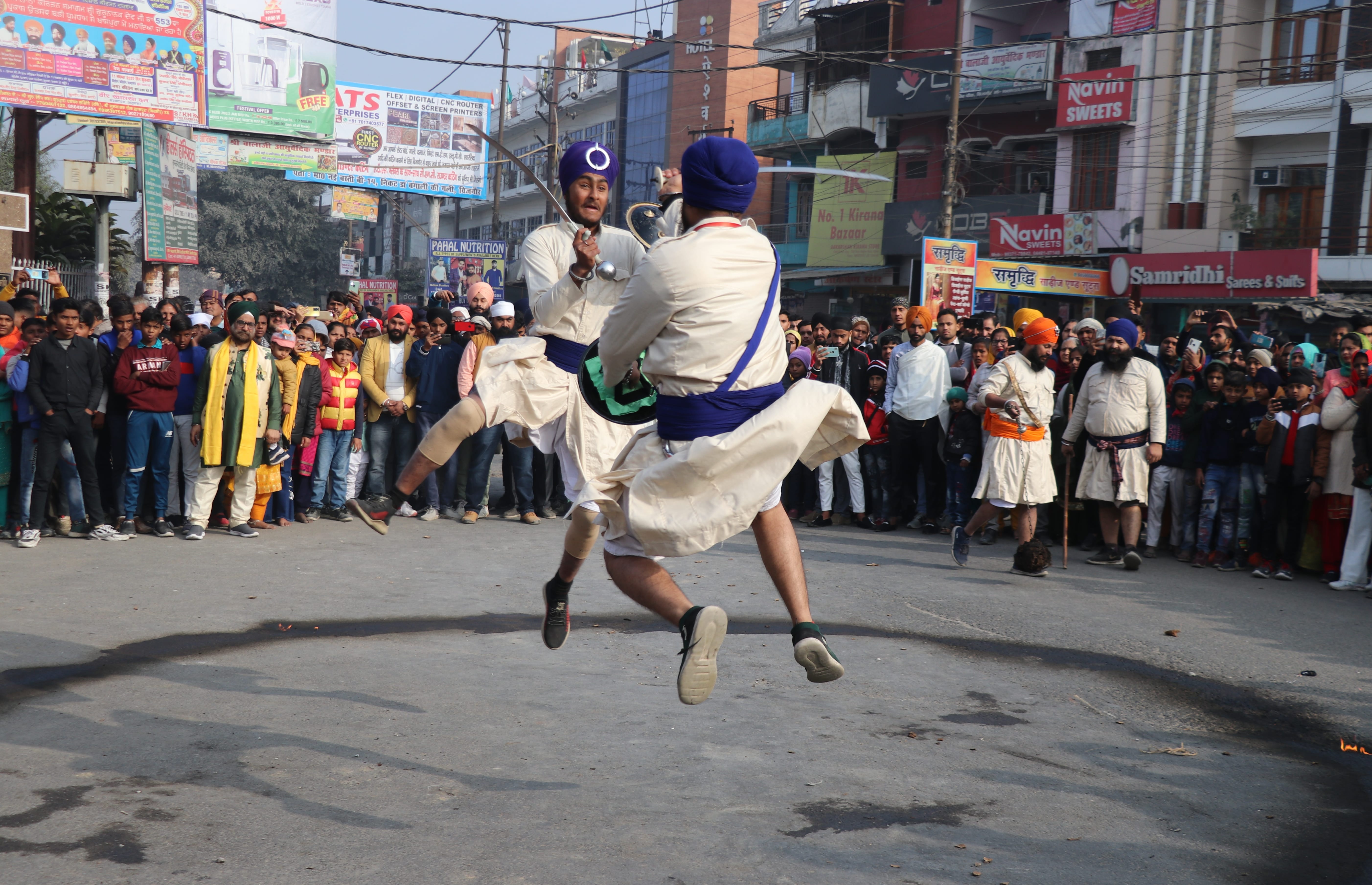 जिनौर में सिखों के नगर कीर्तन में करतब दिखाते कलाकार। जिनौर में सिखों के नगर कीर्तन में करतब दिखाते कलाकार।