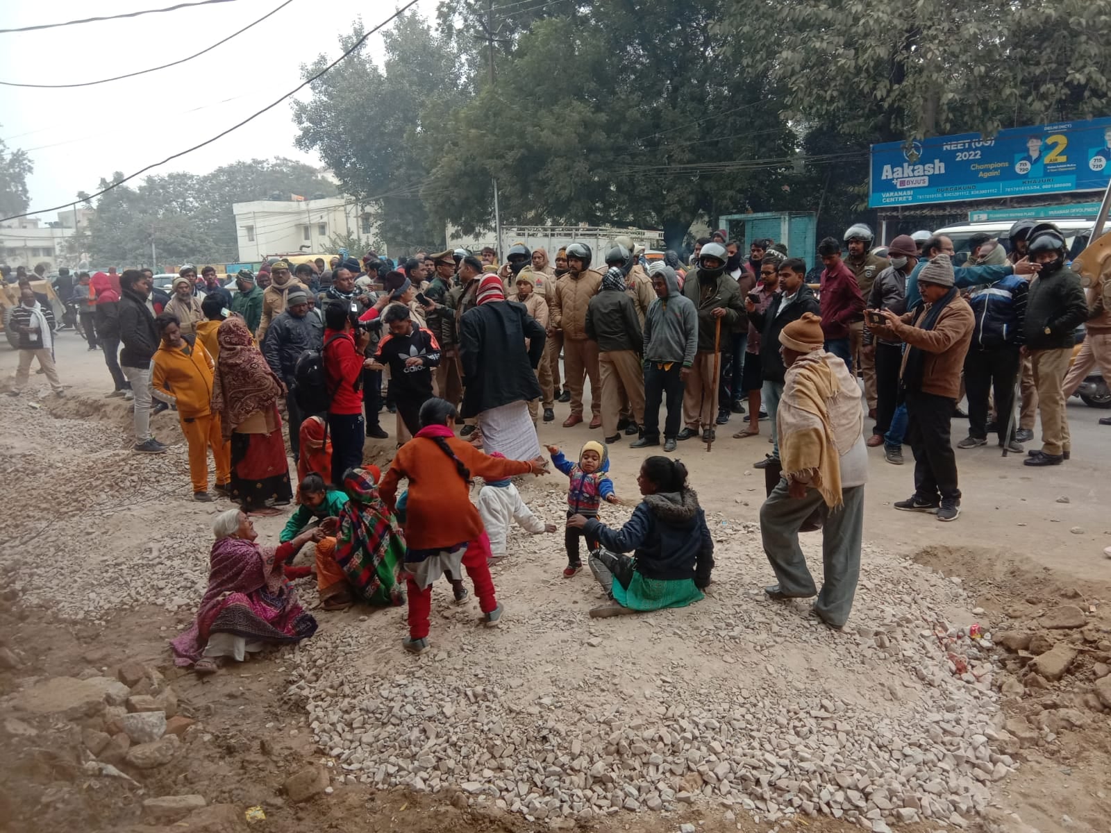 वाराणसी में मंगलवार को भिखारीपुर तिराहे पर अतिक्रमण हटाओ अभियान का जमीन पर लेटकर विरोध करती महि?