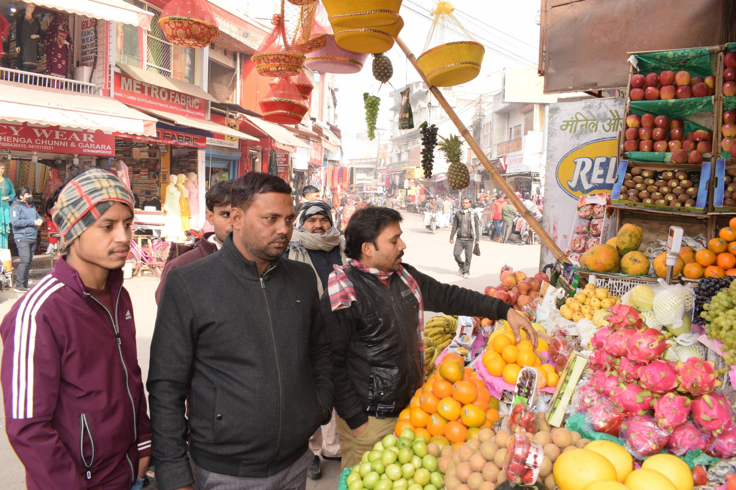 बिना मास्क लगाए बहादुरगंज बाजार में फल खरीदते लोग । संवाद बिना मास्क लगाए बहादुरगंज बाजार में फल खरीदते लोग । संवाद
