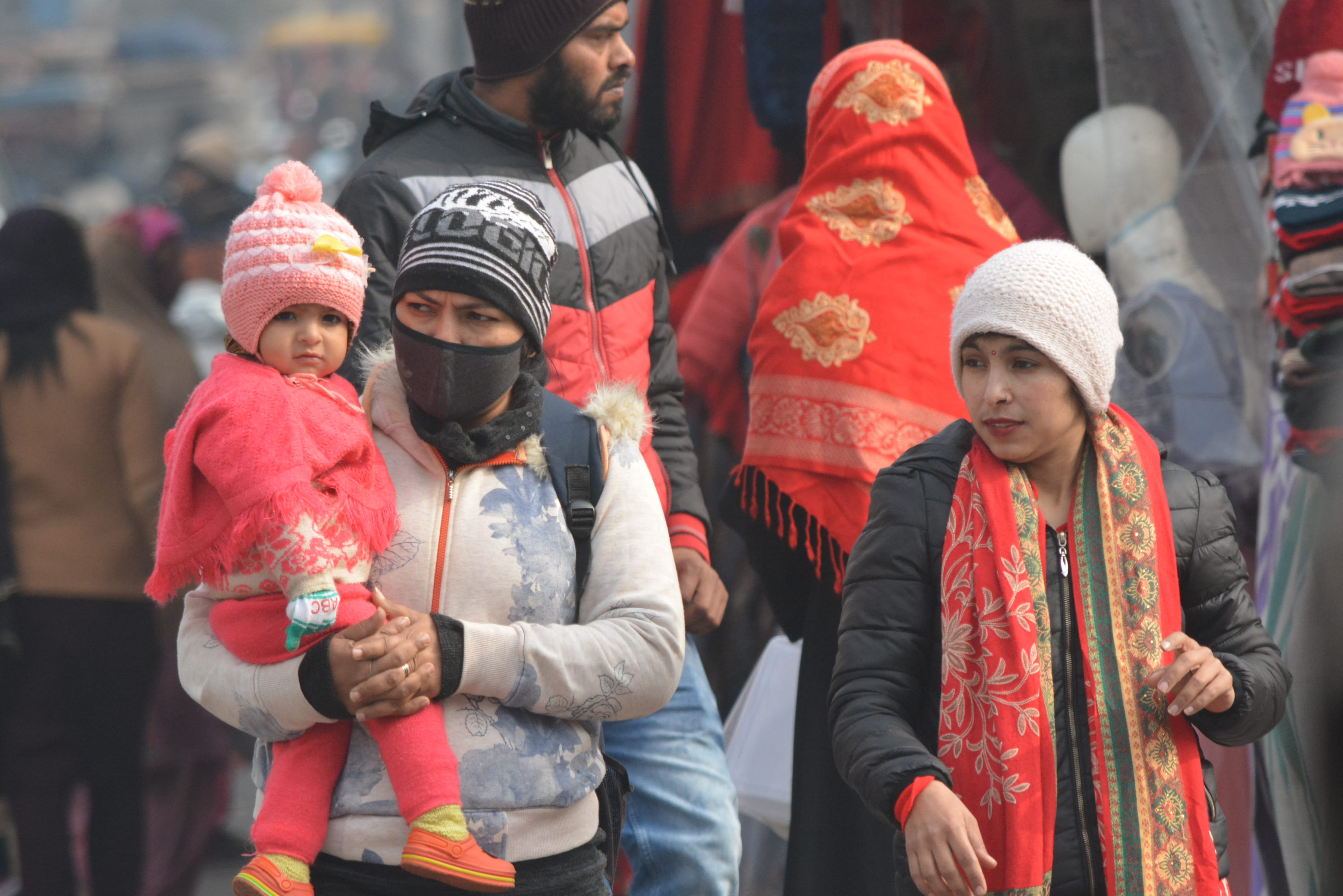 कडाके की ठंड में बच्चें को ऊनी कपडें में लेकर गंतव्य को जाती महिला। कडाके की ठंड में बच्चें को ऊनी कपडें में लेकर गंतव्य को जाती महिला।