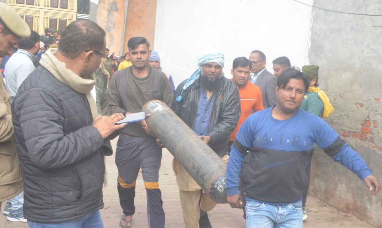 फूलगढ़ी स्थित बोरवेल में बच्चे के गिरने के बाद ऑक्सीजन का सिलेंडर ले जाते लोग। संवाद