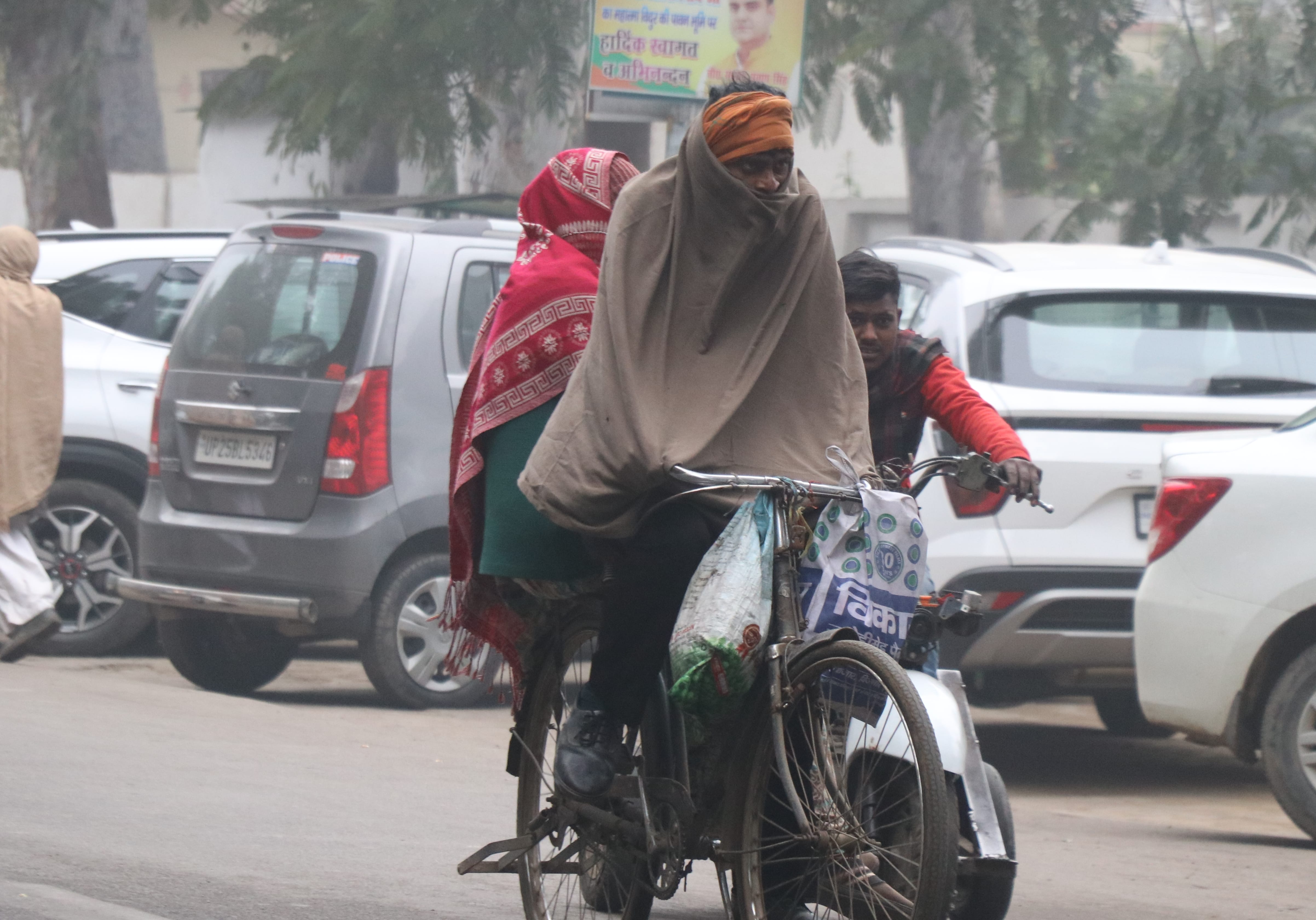 जिनौर में कड़ाके की ठंड में साइकिल पर लिपटकर जाता साईकिल सवार।