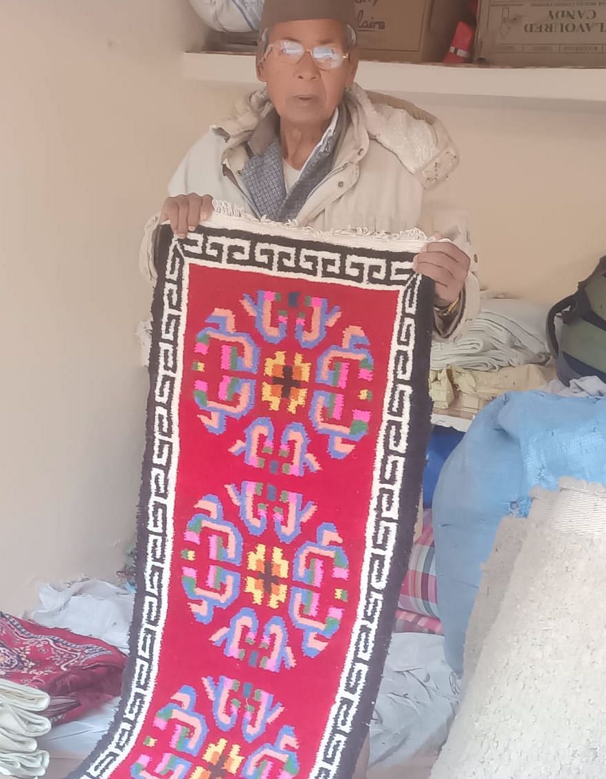 बागेश्वर के उत्तरायणी मेले में हस्तनिर्मित दन दिखाते बूंगा गांव के कालू राम। संवाद