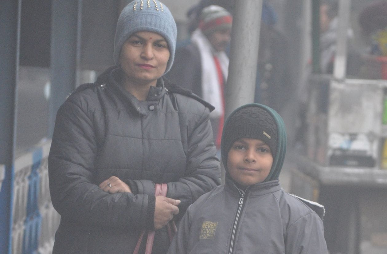 स्टेशन पर ठंड में ट्रेन आने का इंतजार करती महिला । संवाद स्टेशन पर ठंड में ट्रेन आने का इंतजार करती महिला । संवाद