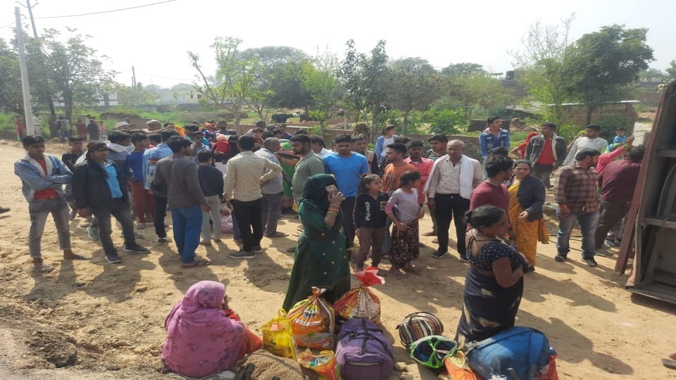 पलटी बस को देखते ग्रामीण